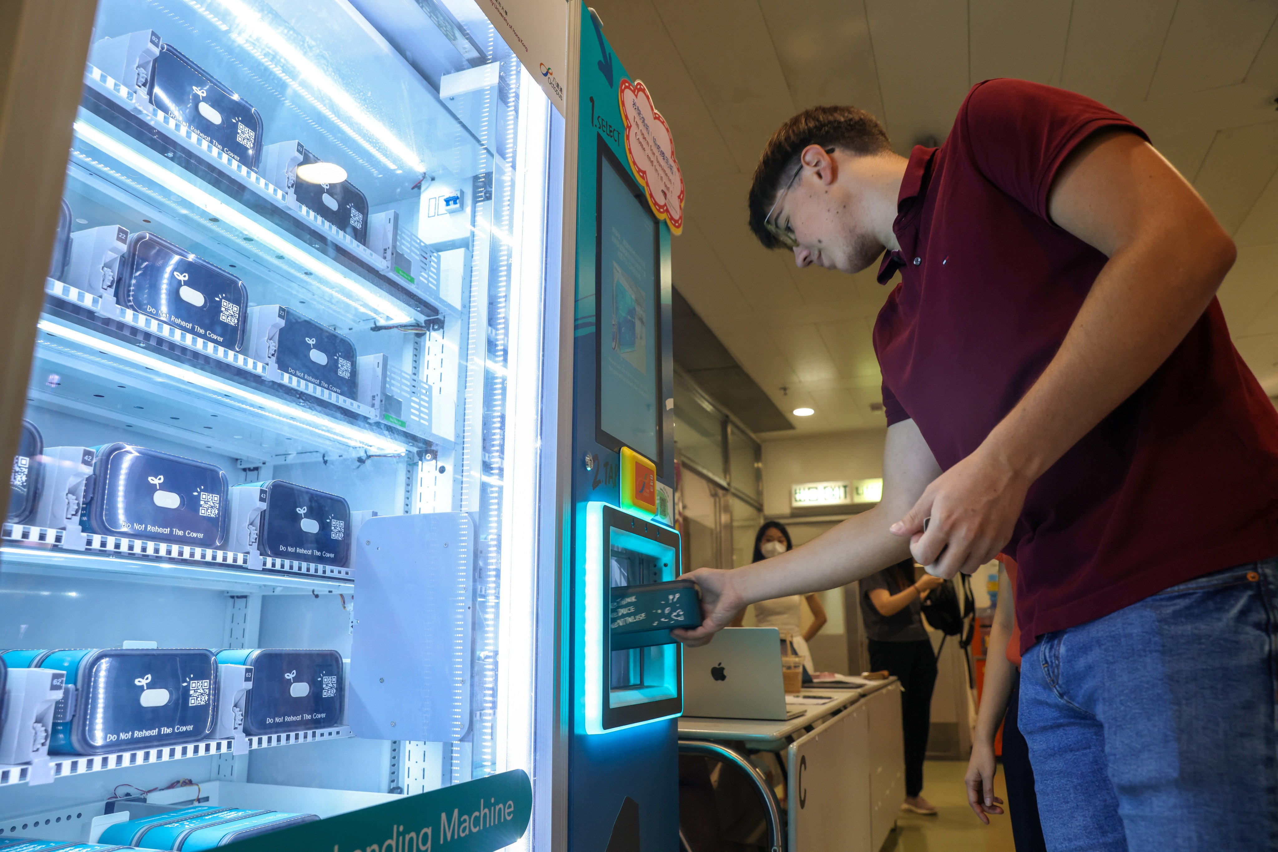 A student gets an eco-friendly reusable lunch box from a machine at City University. Photo: Yik Yeung-man