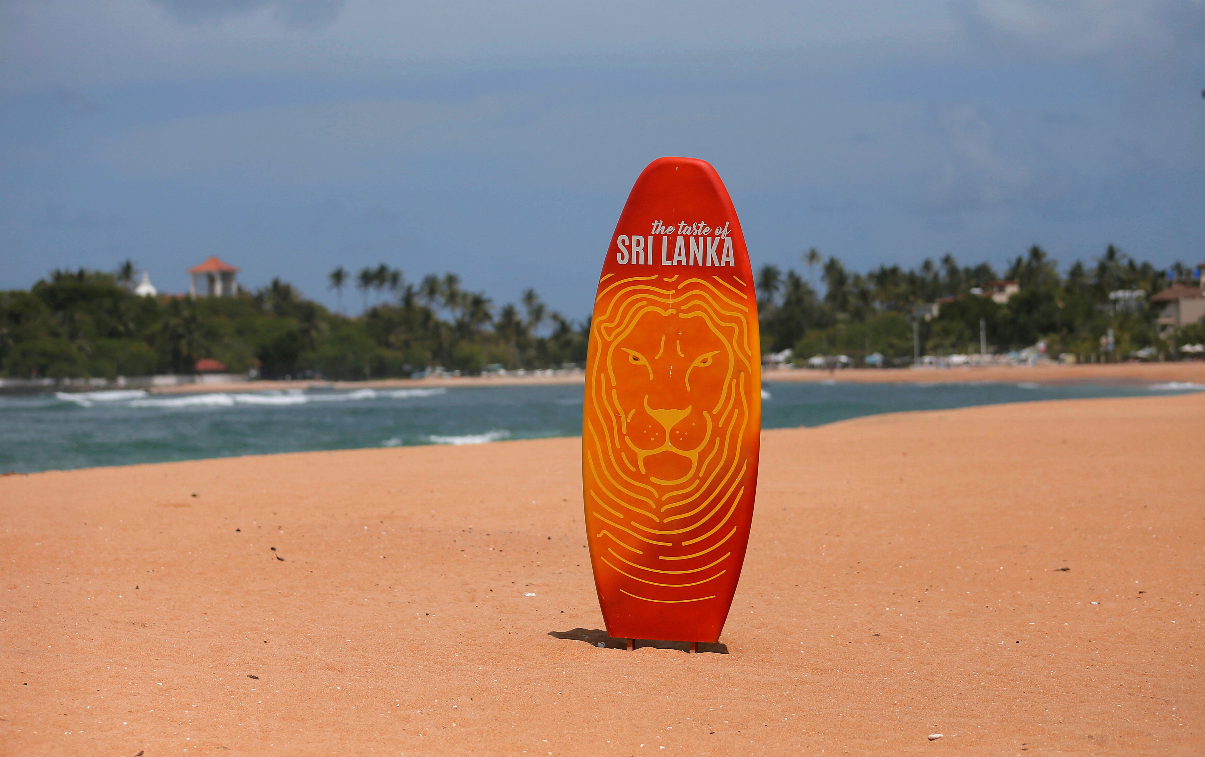 A surfboard is seen in the middle of an empty beach near hotels in Galle, Sri Lanka. Photo: Reuters