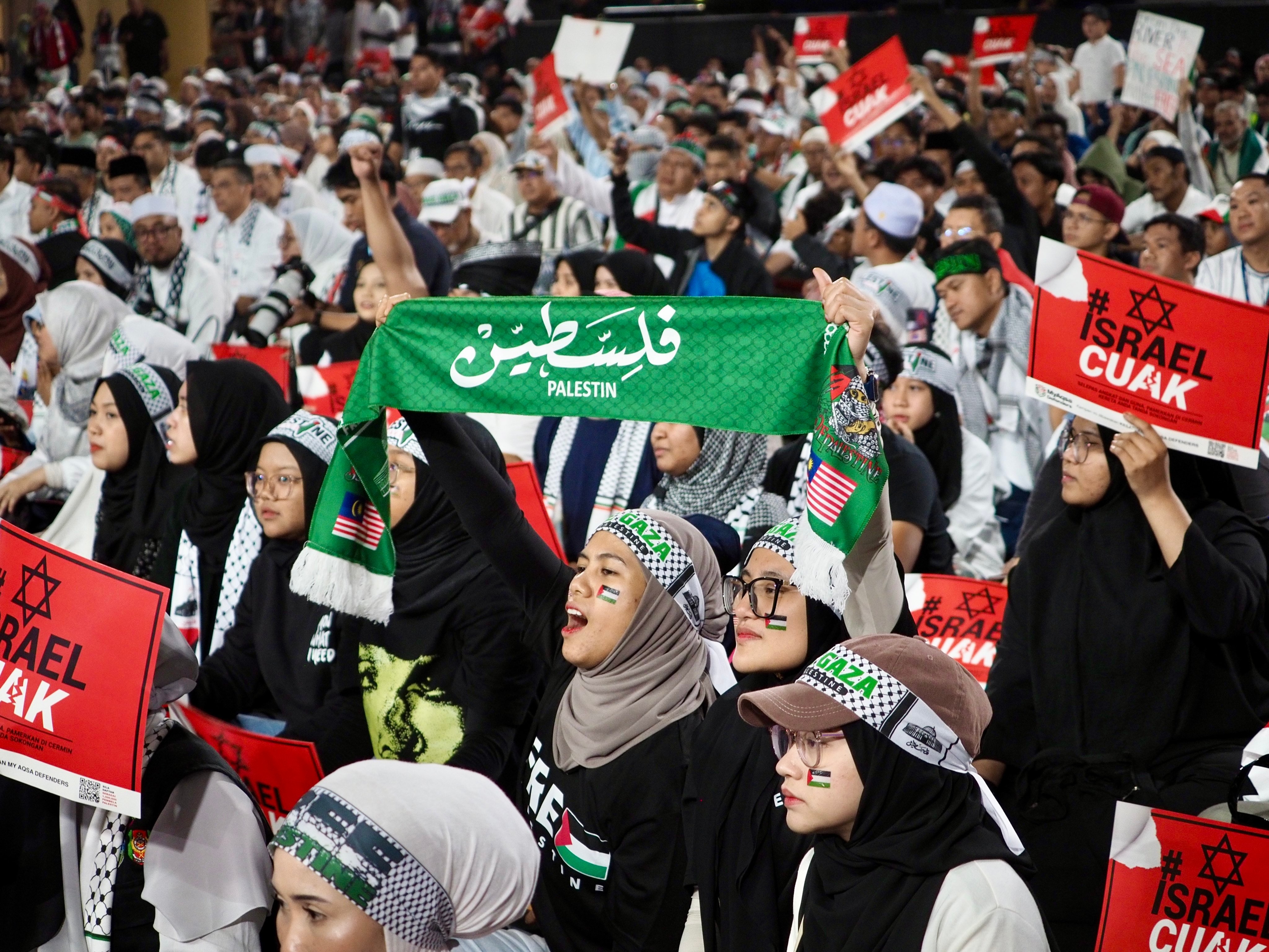 Malaysian Muslims hold up signs and slogans at a pro-Palestine rally in a Kuala Lumpur stadium on Tuesday: Photo: Hadi Azmi