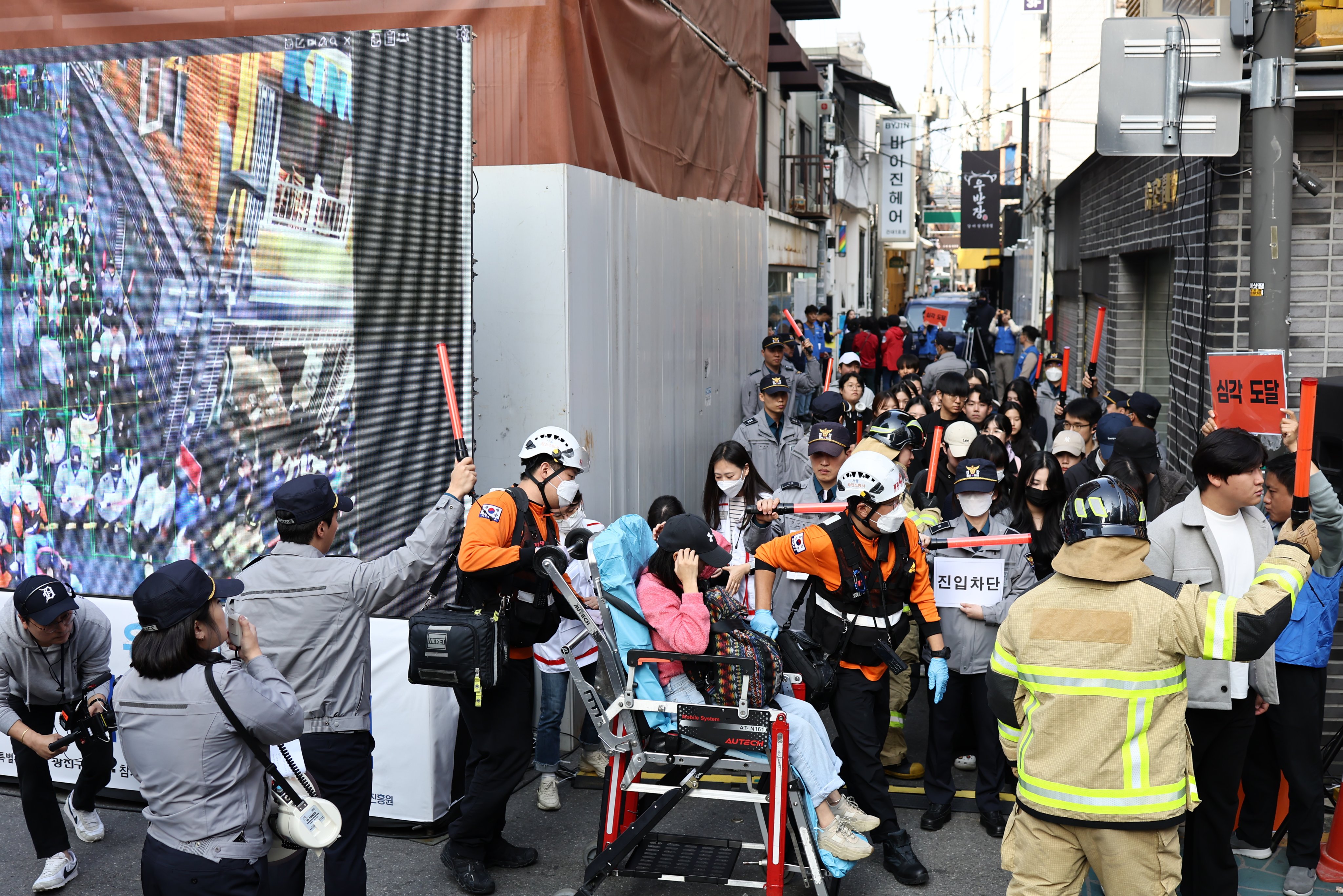 People take part in a drill, conducted by the police to demonstrate how to operate a crowd alert sensor system to control and reduce crowd surges. Photo: EPA-EFE