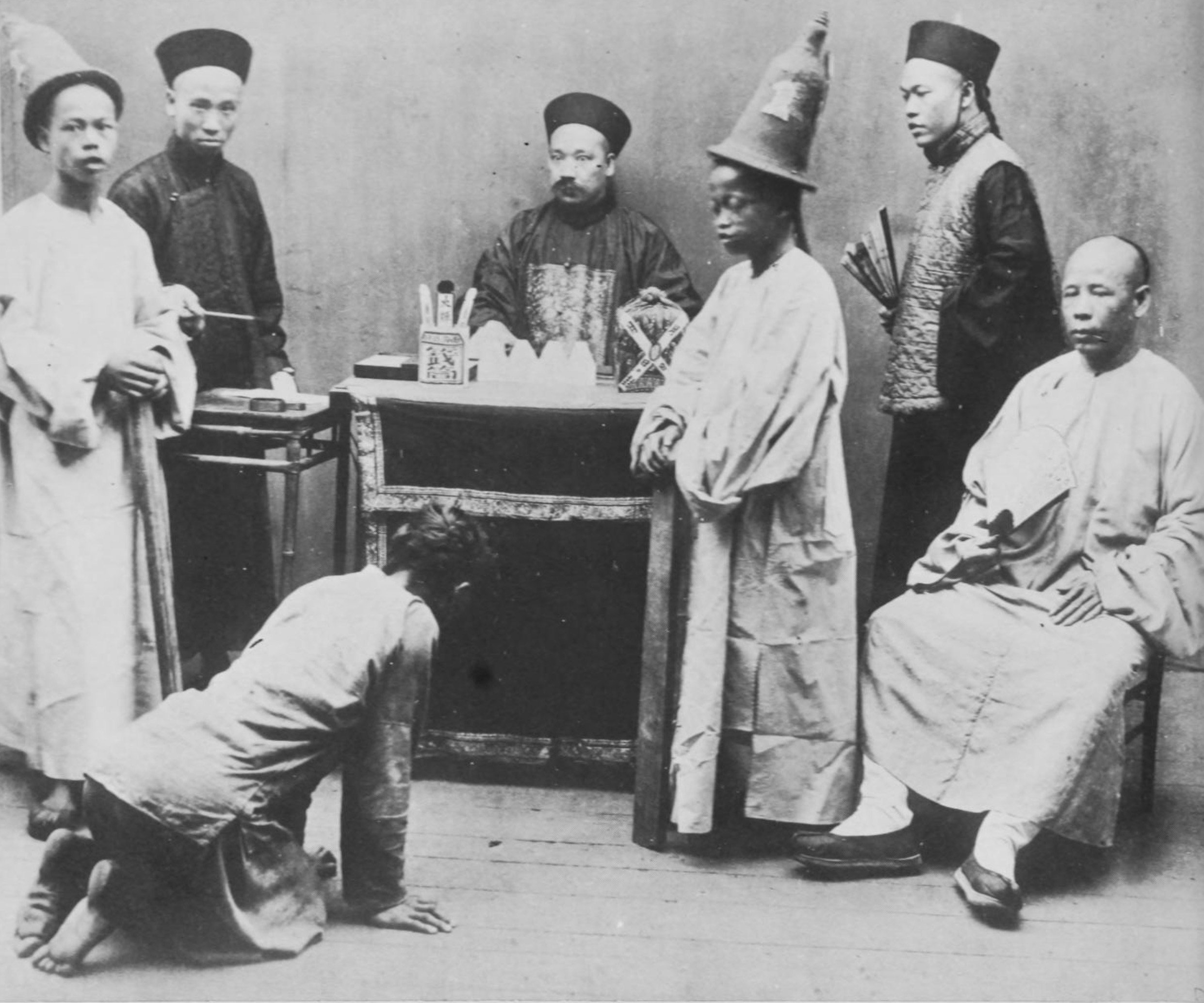 A photograph from “Hong Kong 100 Years Ago - A Picture-Story of Hong Kong in 1870” showing a Chinese court of justice in the then British colony with district magistrate, clerks, court policemen, the accused and a prosecutor (seated). 