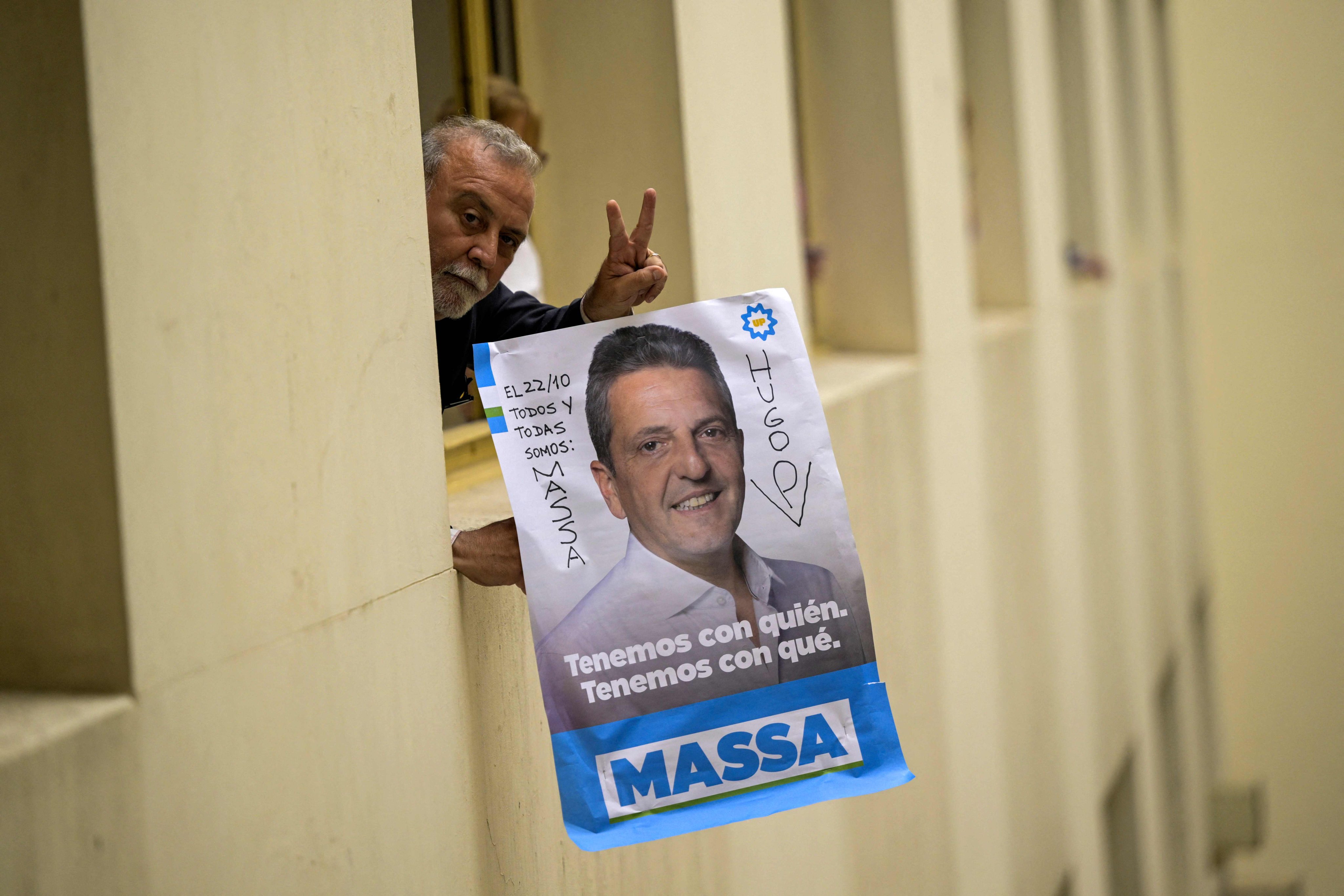 A worker holds a poster of Argentine economy minister Sergio Massa, in Buenos Aires on October 23, a day after Massa won the first round of the presidential election. Massa and anti-establishment outsider Javier Milei are set for a run-off presidential poll next month in a contest between two wildly different versions of the country. Photo: AFP