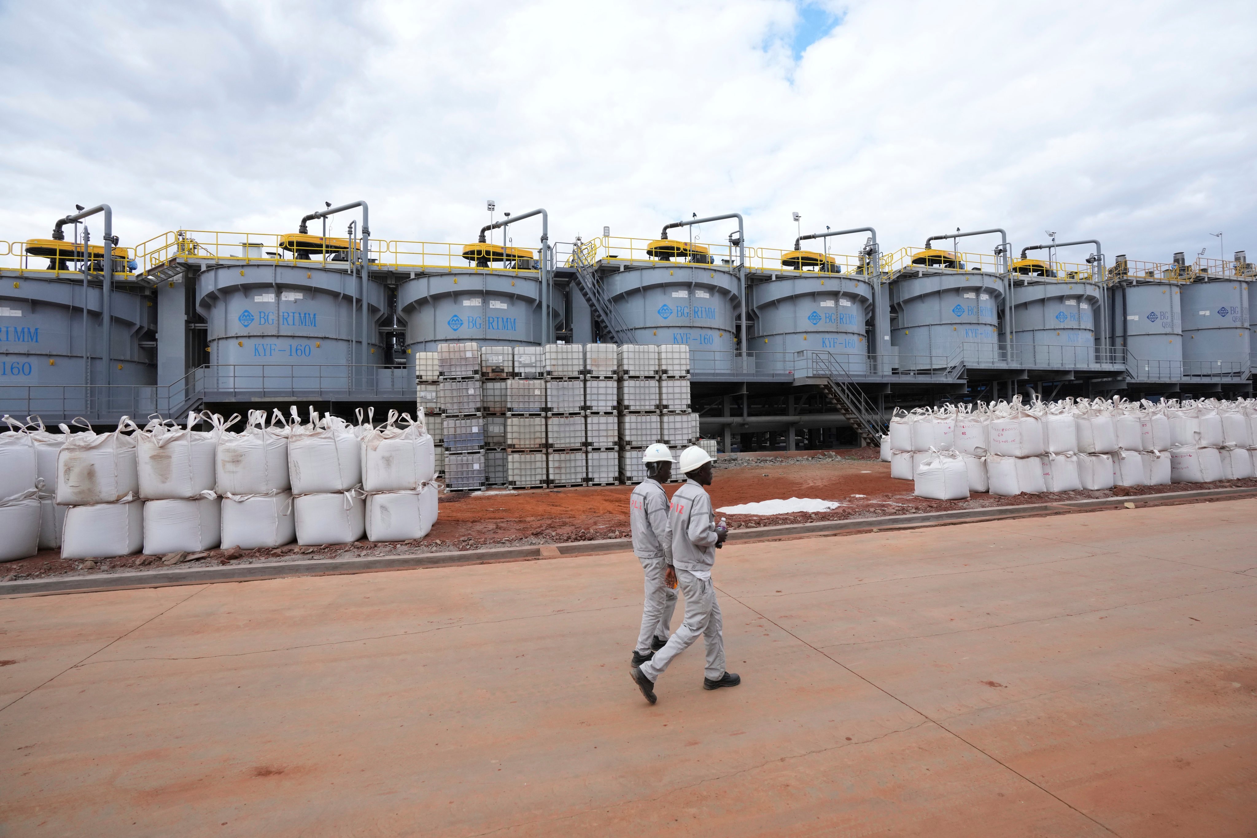 Workers walk past lithium filled bags at a processing plant in Zimbabwe. Raw materials like lithium are taking on heightened importance as the world moves to higher-end technology and electric vehicles. Photo: AP