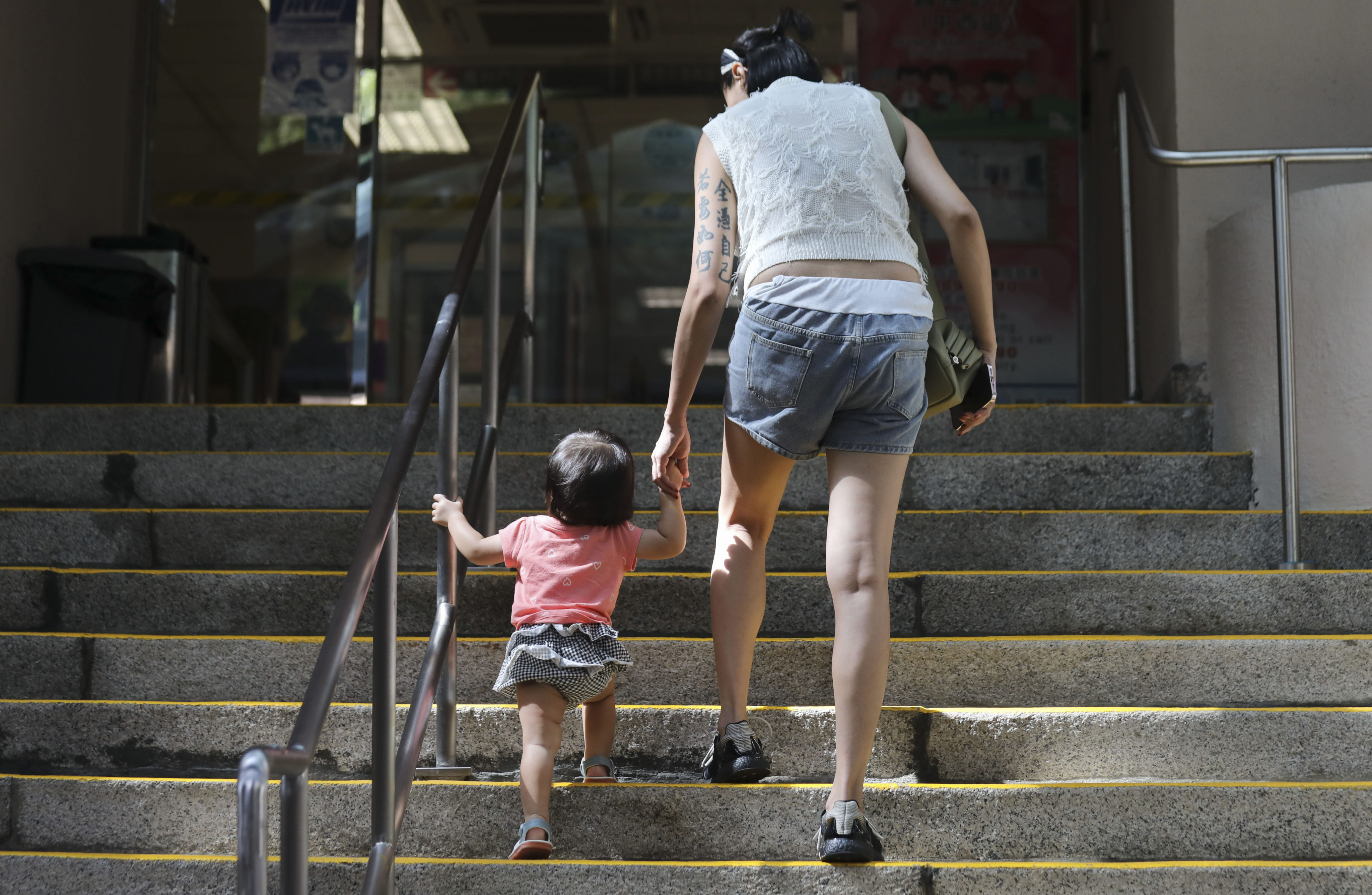 A woman with a toddler goes to Tsan Yuk Hospital in Sai Ying Pun. Hong Kong’s plummeting birth rate should be addressed holistically, with a refreshed population strategy. Photo: Xiaomei Chen
