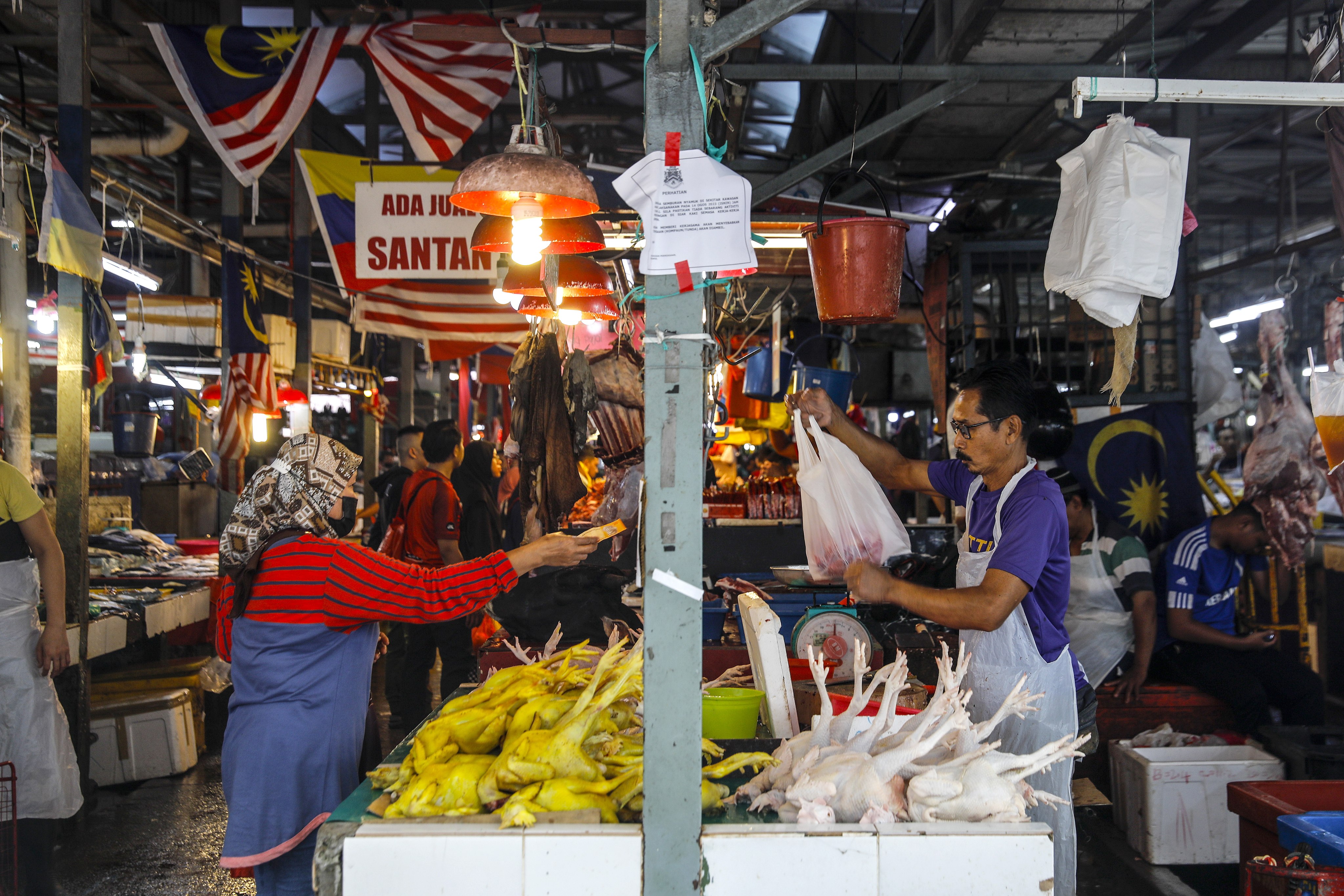 A customer buys a chicken at a wet market in Kuala Lumpur. Photo: EPA-EFE