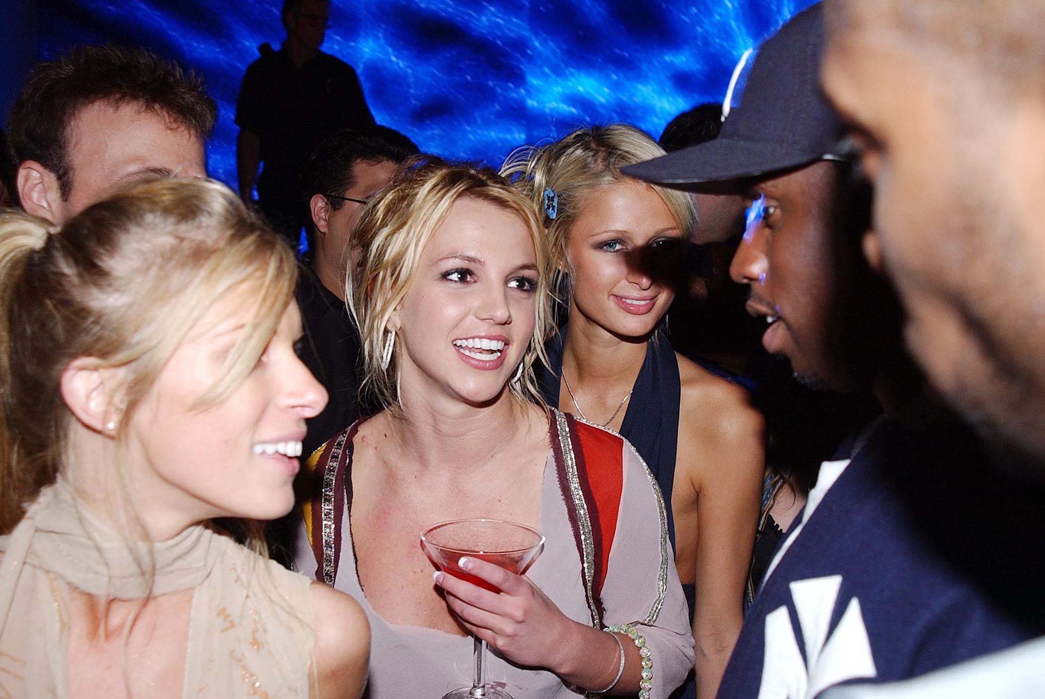 Britney Spears (centre) at a party in Los Angeles in October 2002 with Paris Hilton and Sean “P Diddy” Combs and other guests. The singer’s new book, “The Woman in Me” talks about everything from dating Justin Timberlake to her abortion and conservatorship. Photo: Getty Images