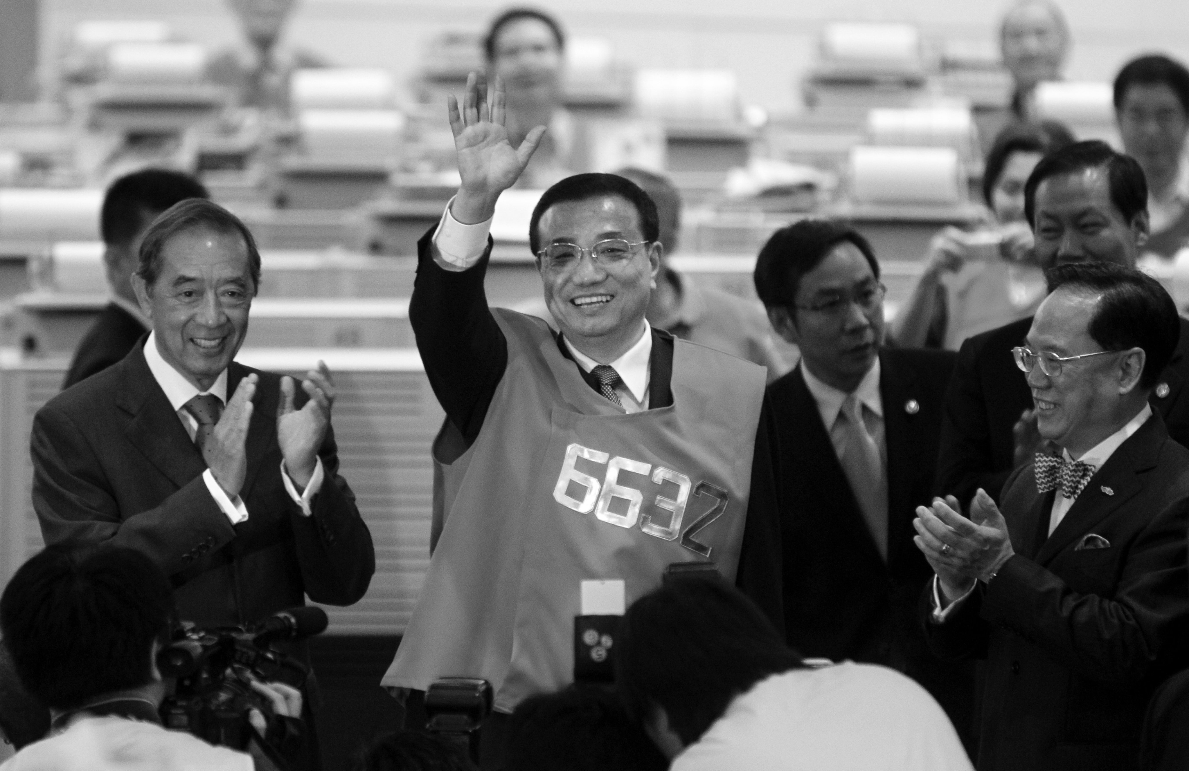 Li Keqiang (centre) dons a trader’s visit during a visit to Hong Kong’s stock exchange in August 2011. Photo: David Wong