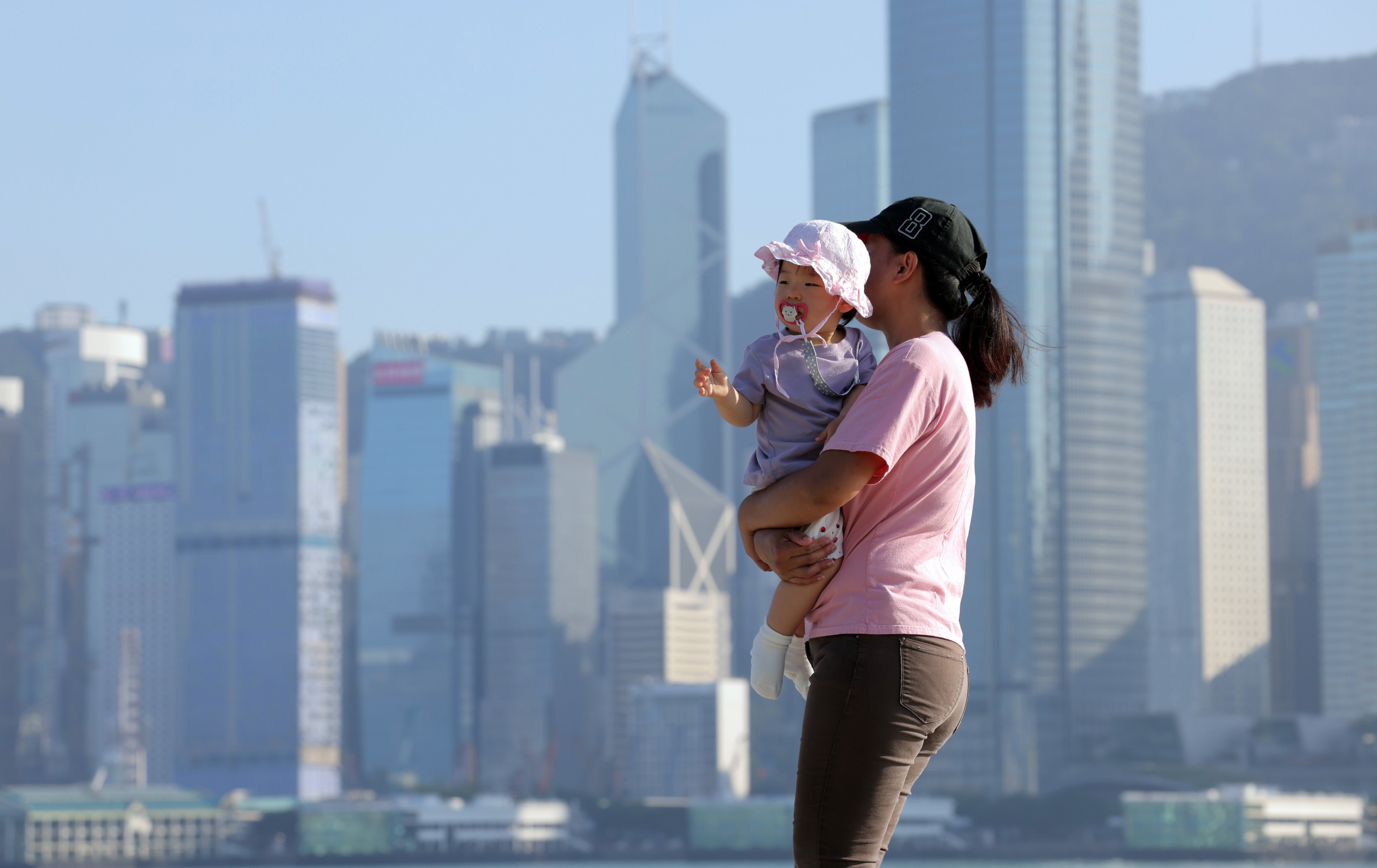 A mother carries her child at the West Kowloon Art Park on October 25. This year’s policy address included several measures aimed at raising the city’s birth rate, including a cash payment for each child born. Photo: Jelly Tse