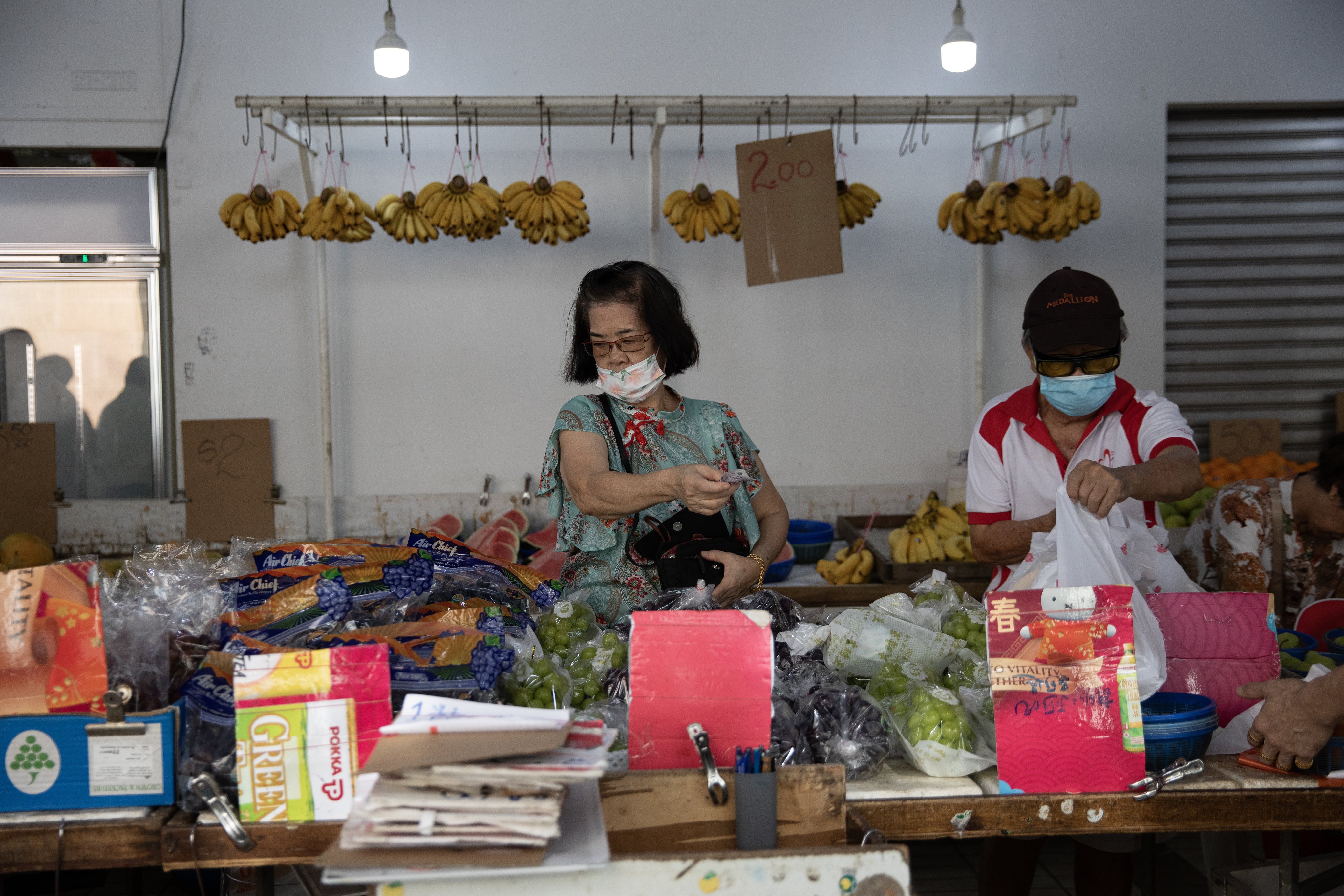 People buy fruit at a neighbourhood market in Singapore. The city state’s core inflation rate, which excludes private transport and accommodation costs, declined to 3 per cent in September from 3.4 percent in August, according to official data. Photo: EPA-EFE