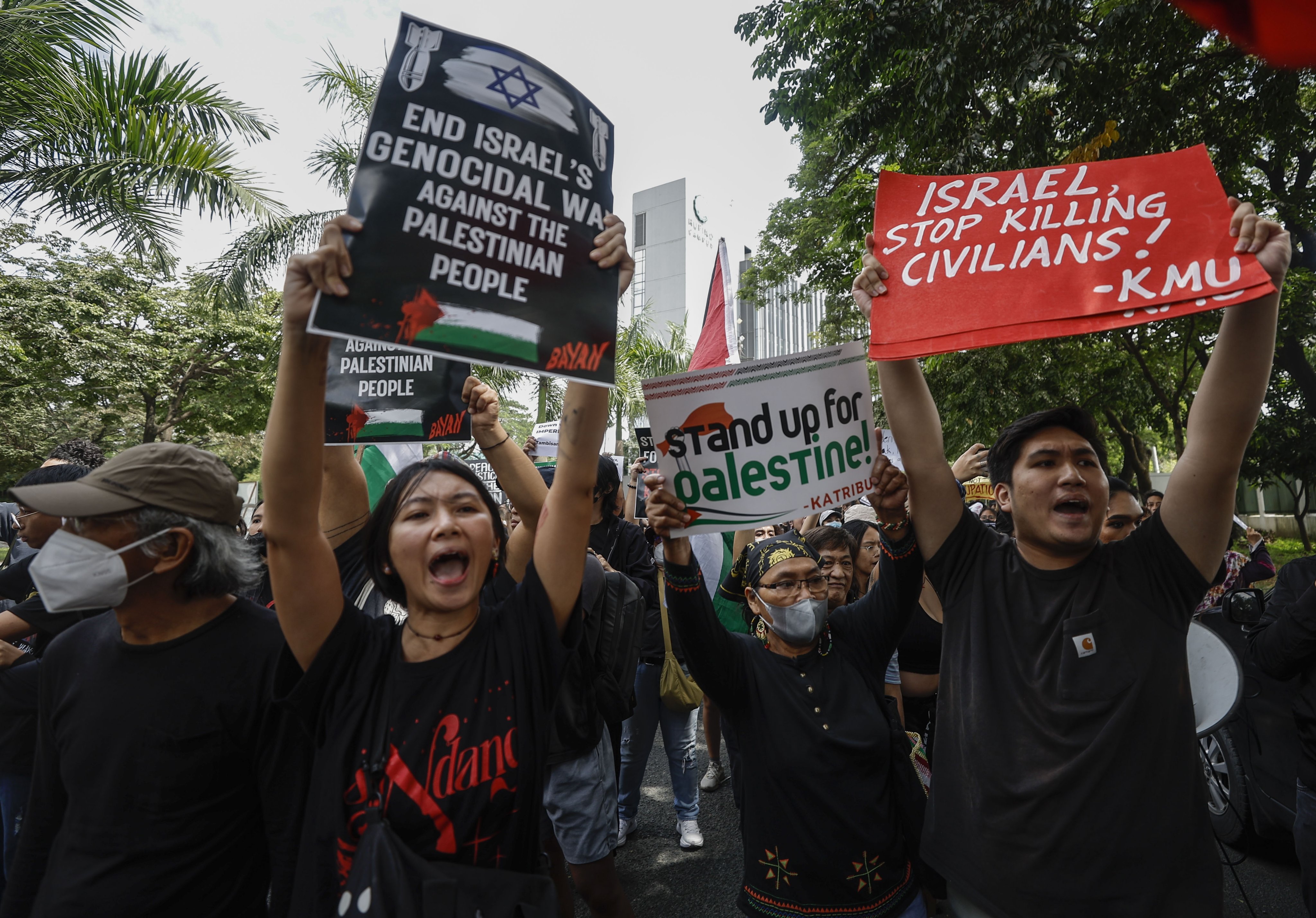 Protesters carry placards at a rally in support of the Palestinian people in Taguig City, Metro Manila, on Tuesday. Photo: EPA-EFE