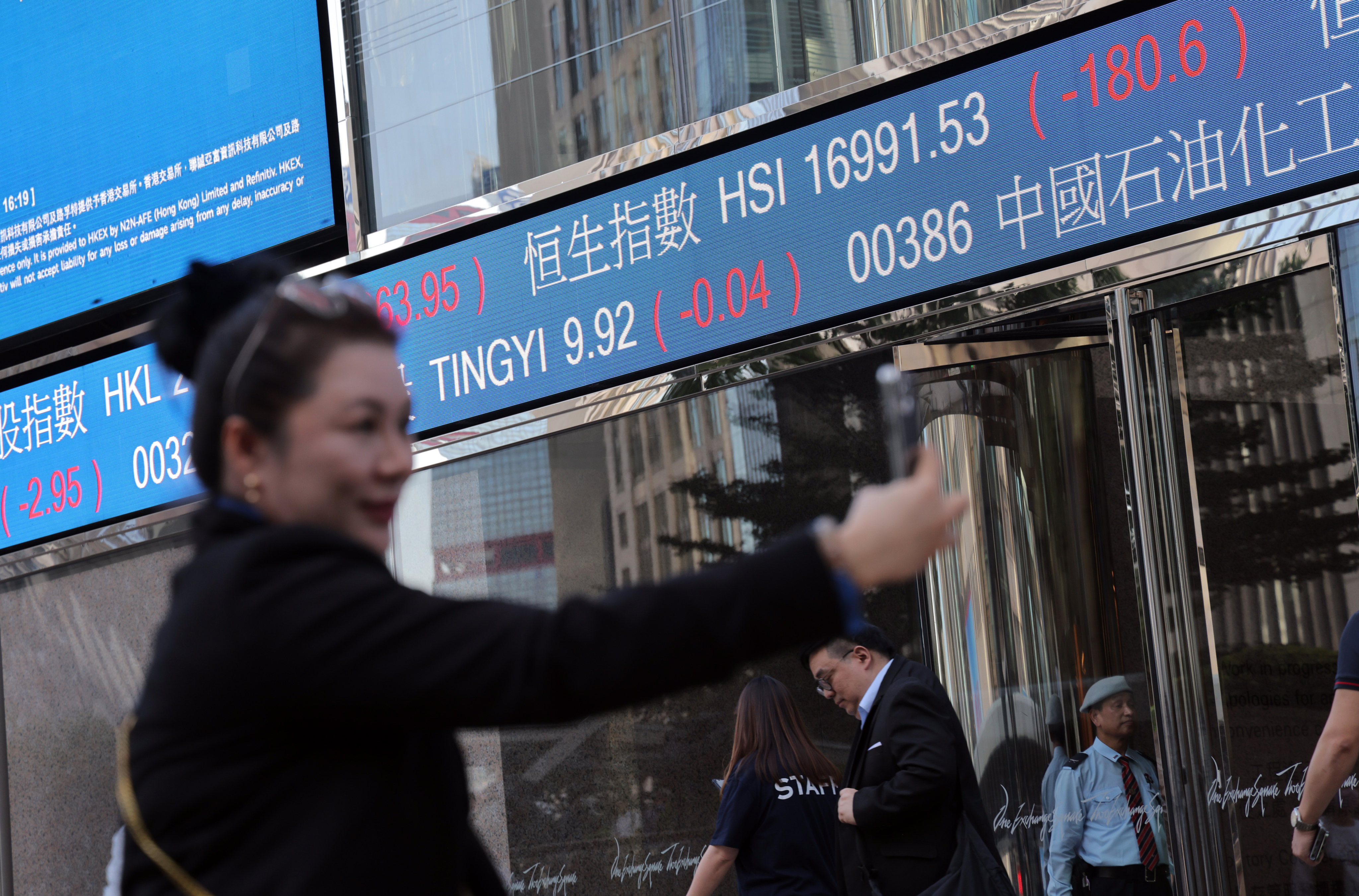 A woman takes a selfie near a screen showing the Hang Seng stock index outside Exchange Square in Central, Hong Kong, on October 24. Photo: Jelly Tse
