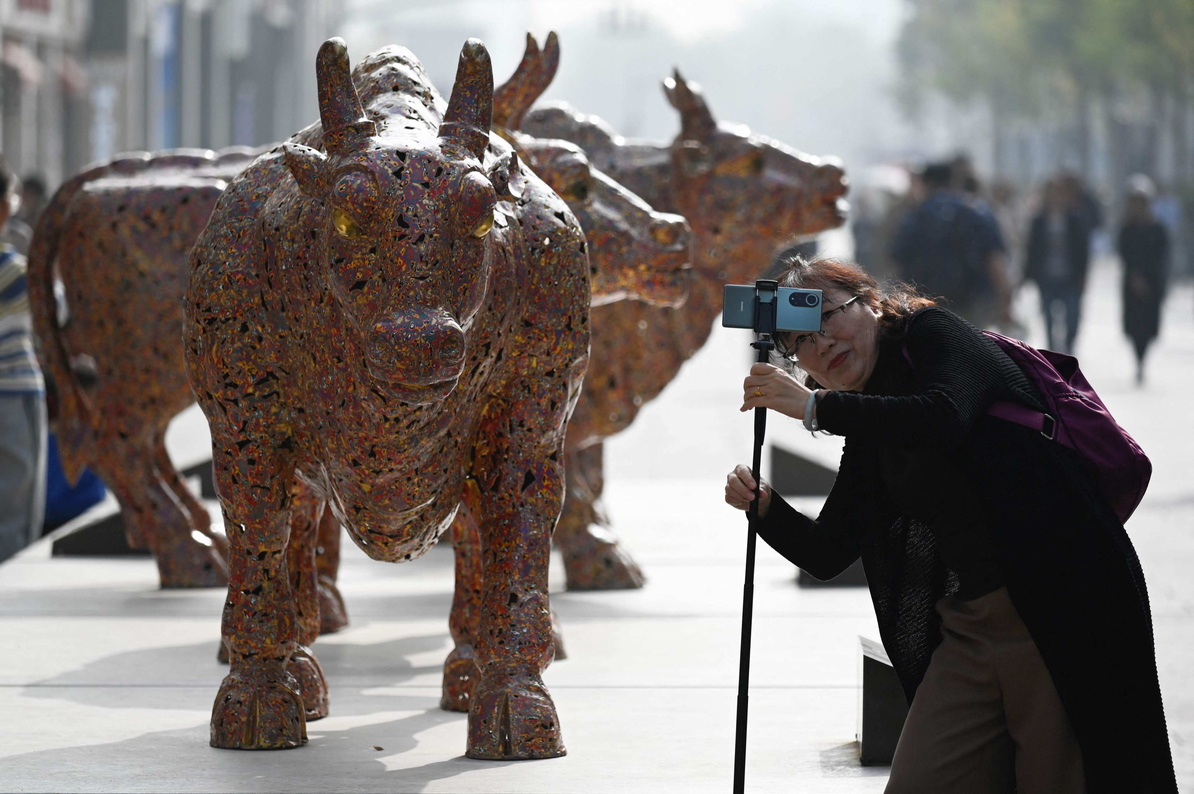 A woman takes a selfie in Beijing on October 31. Despite some bullish economic indicators in recent months, global investors remain hesitant about China’s prospects and are pulling back on their exposure to the country. Photo: AFP
