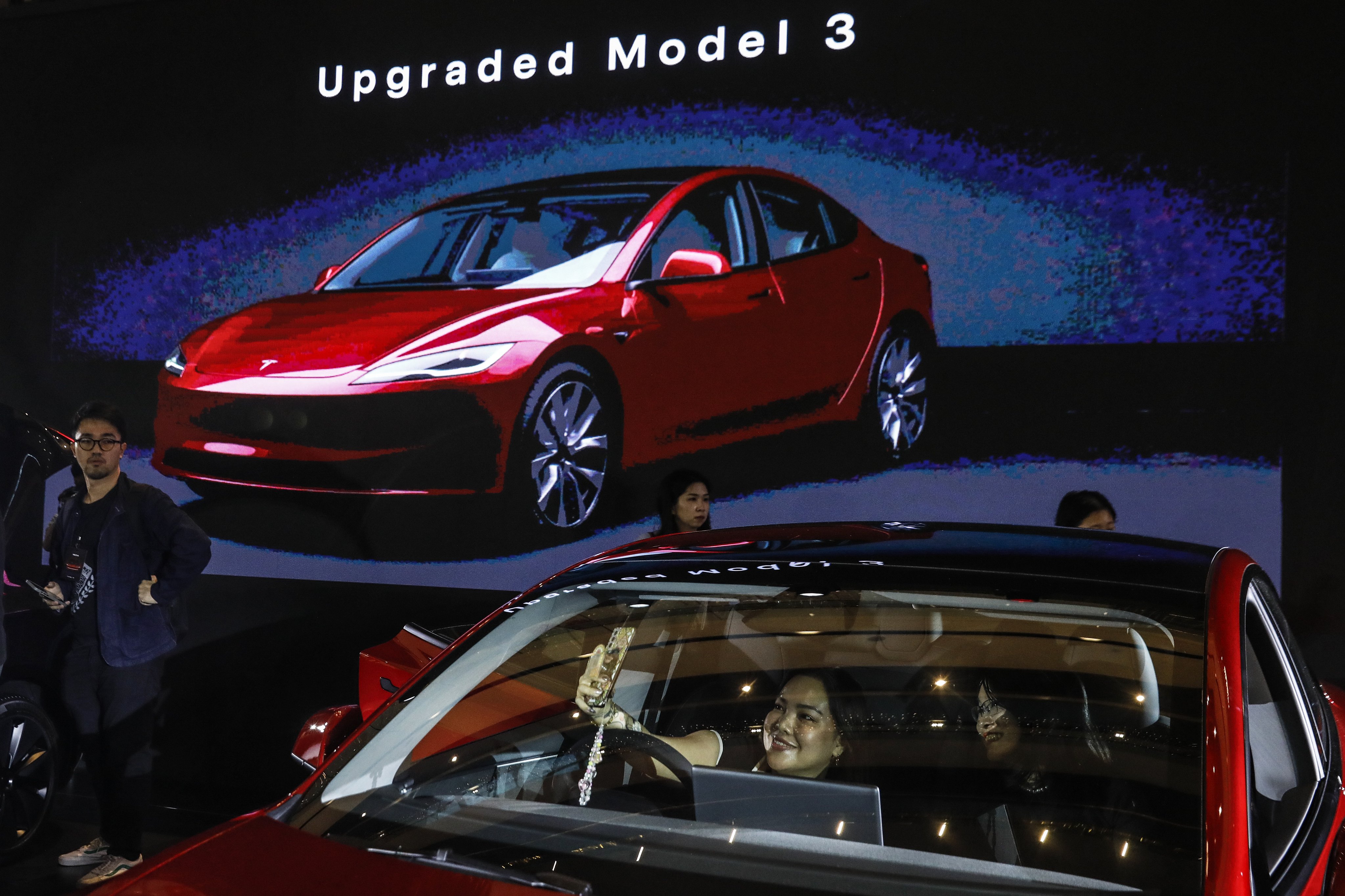 People inspect Tesla’s new Model 3 electric car during an official launch event in Malaysia last month. Photo: EPA-EFE