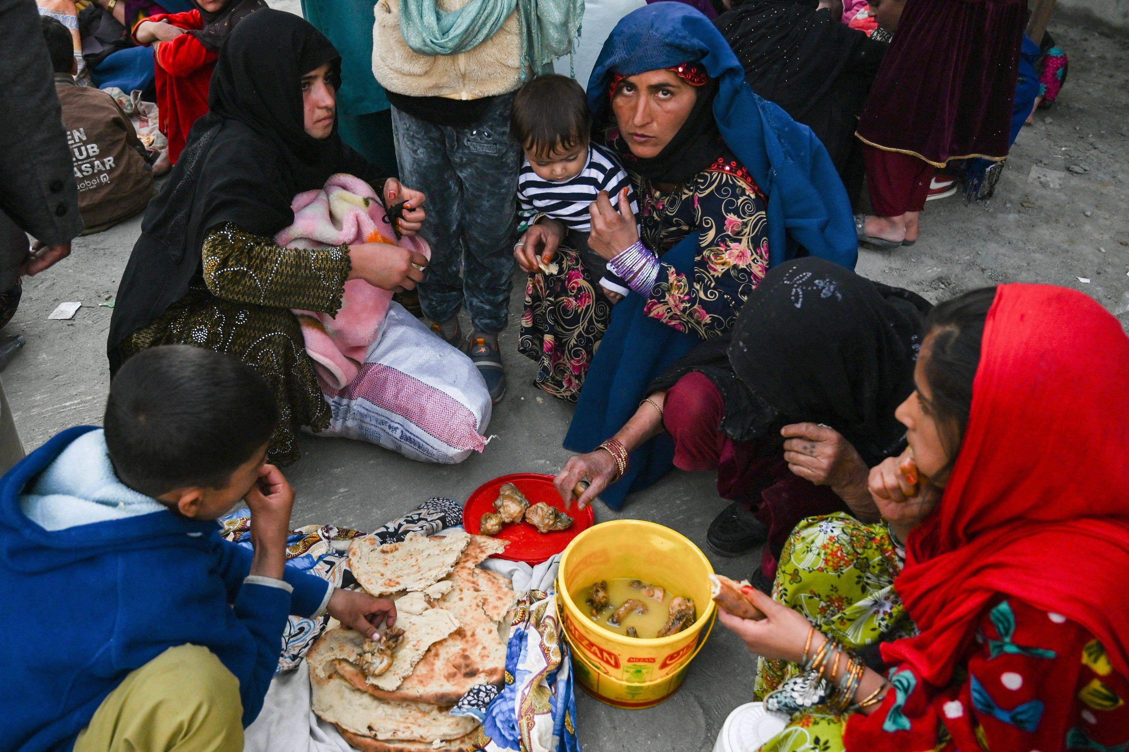 Afghan refugees eat breakfast as they wait to cross the Pakistan-Afghanistan border in Torkham on October 27. Photo: AFP