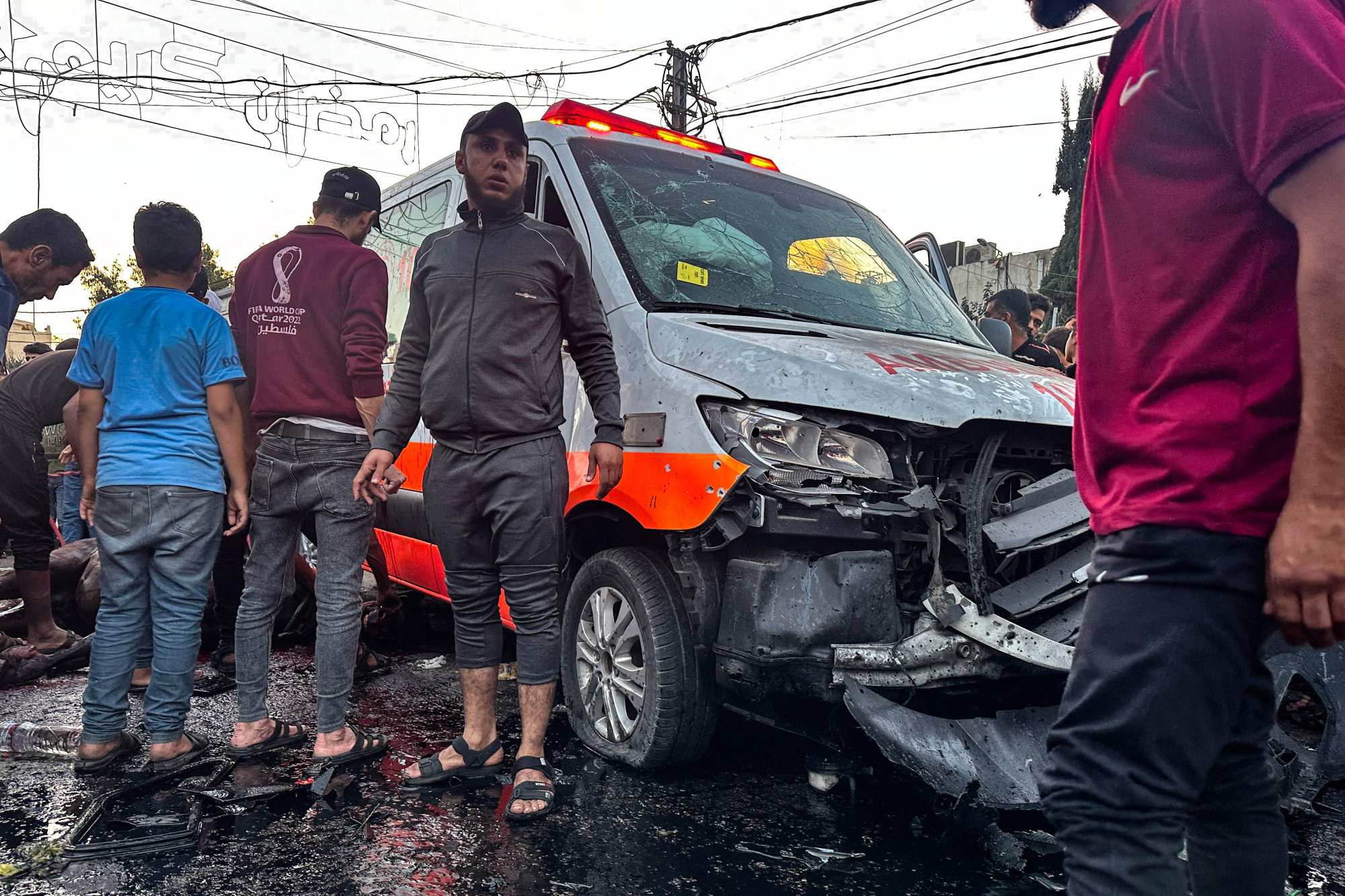 People gather around an ambulance damaged in a reported Israeli strike in front of al-Shifa hospital in Gaza City on Friday. Photo: AFP