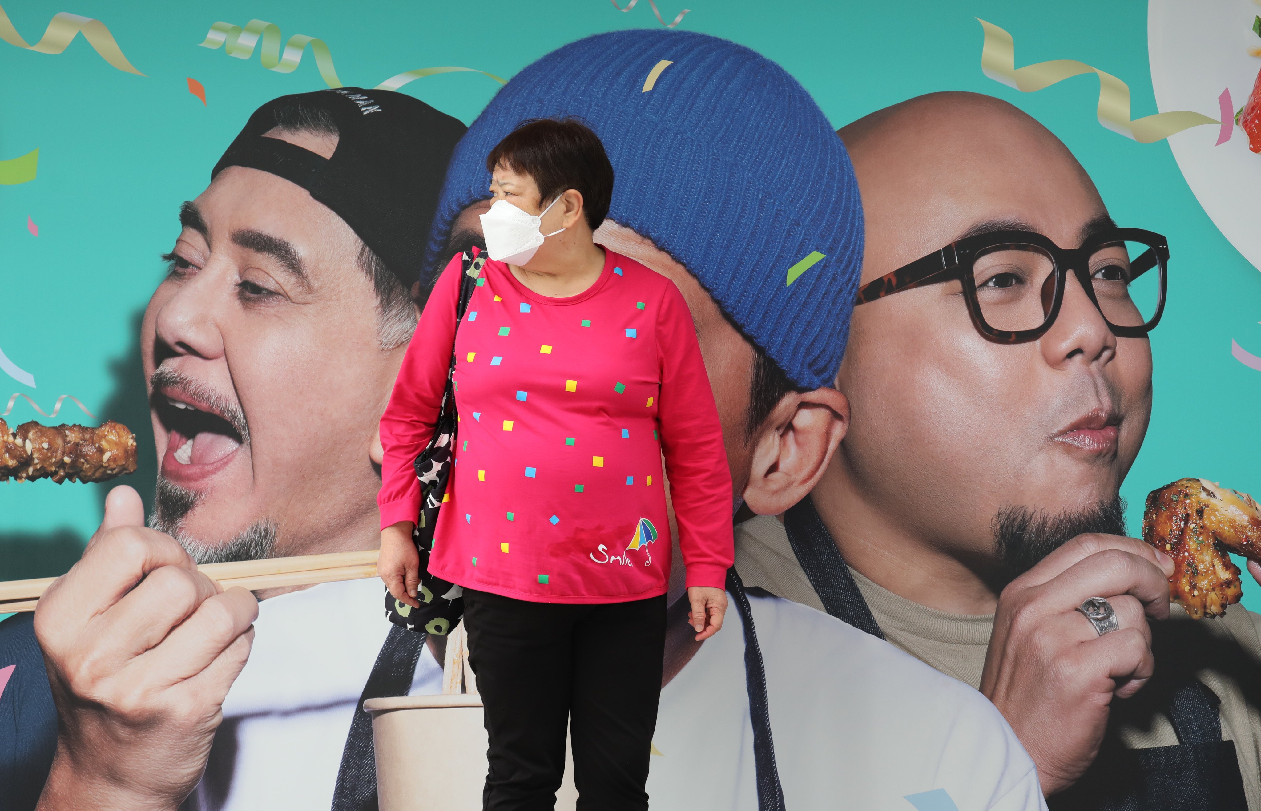 A woman waits at a tram stop, in front of an advertisement hoarding, in North Point on November 5. The government will release its GDP projections on Friday.
Photo: Xiaomei Chen