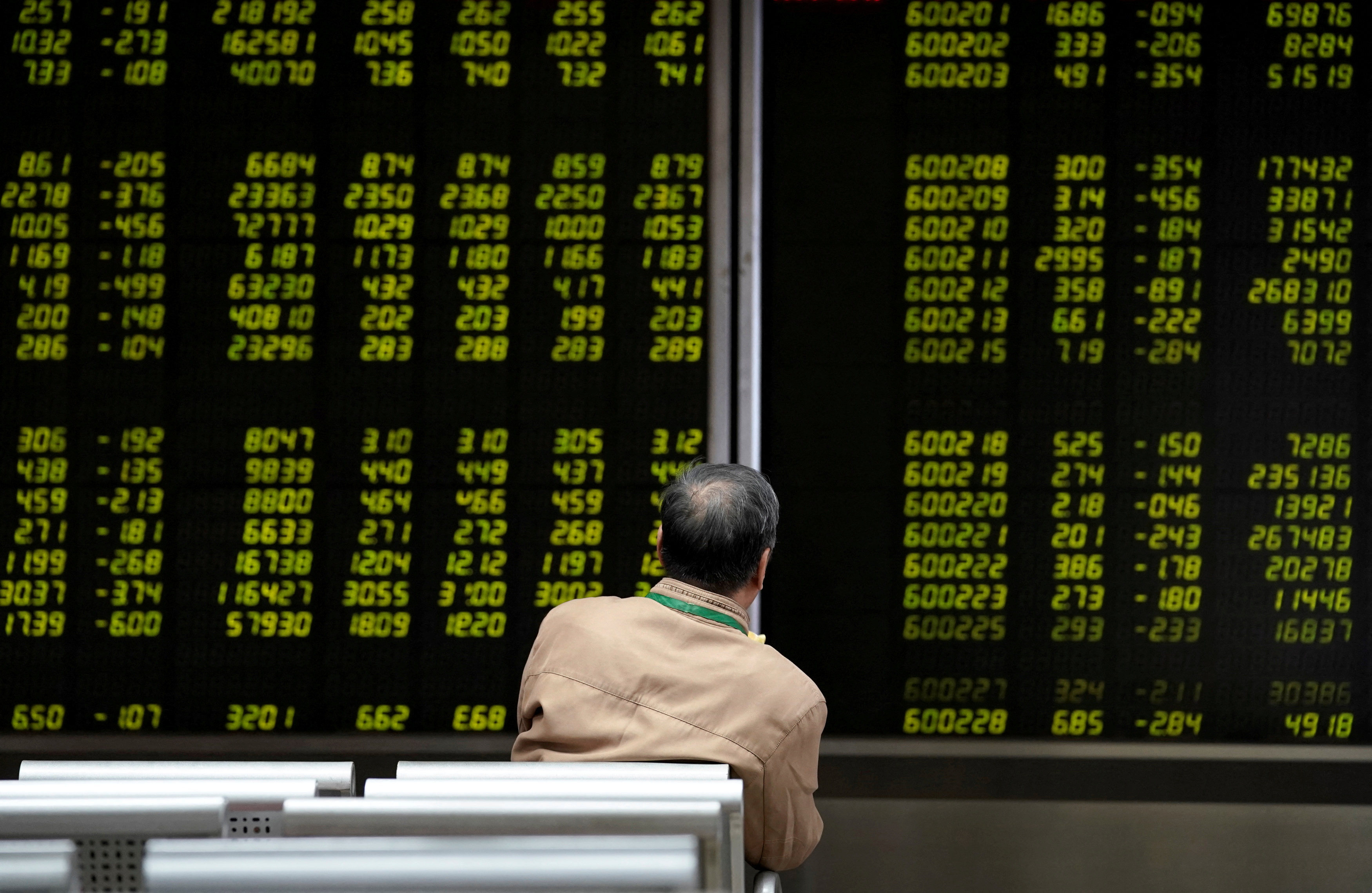An investor watches a board showing stock information at a brokerage office in Beijing, October 8, 2018. Photo: Reuters