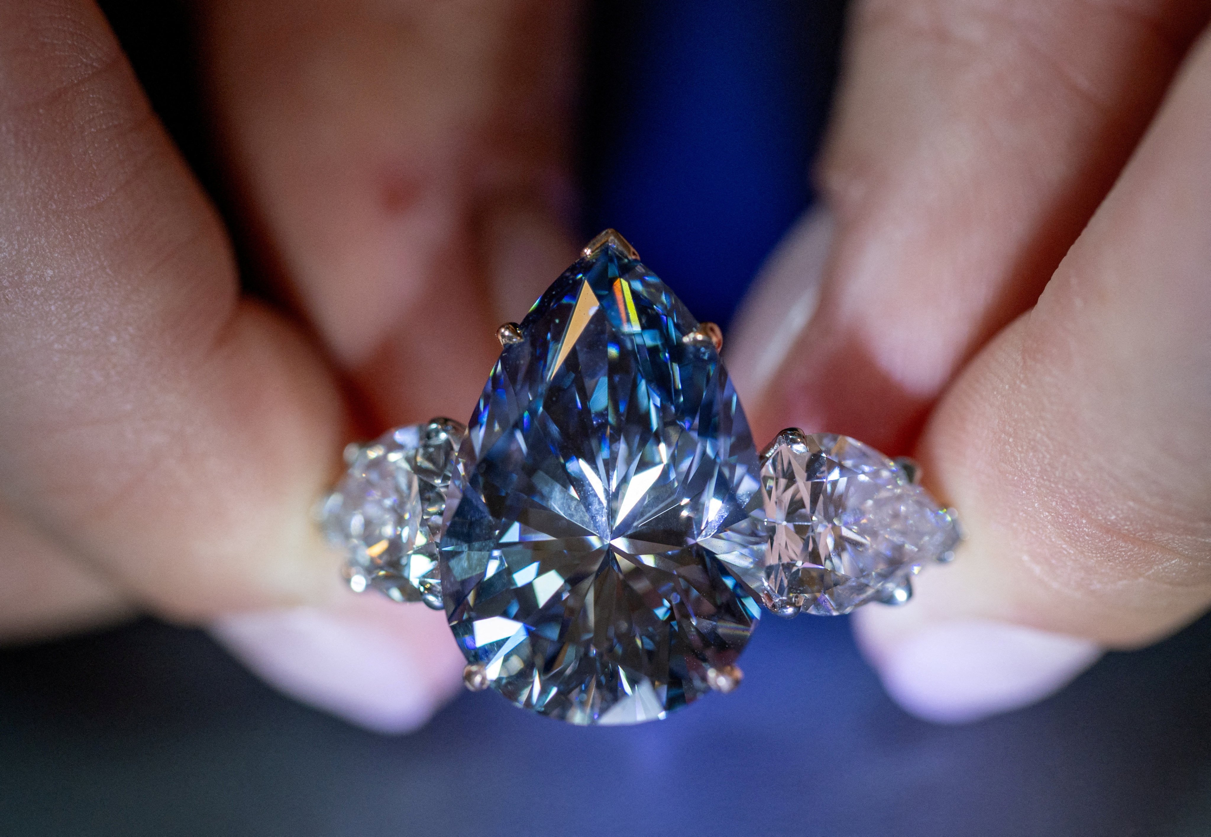 A Christie’s auction house staff member holds the Bleu Royal diamond, weighing 17.61 carats, which is the largest to appear for sale in auction history and that could sell for up to US$50 million, during an auction preview in Geneva, Switzerland, on November 1. Photo: Reuters