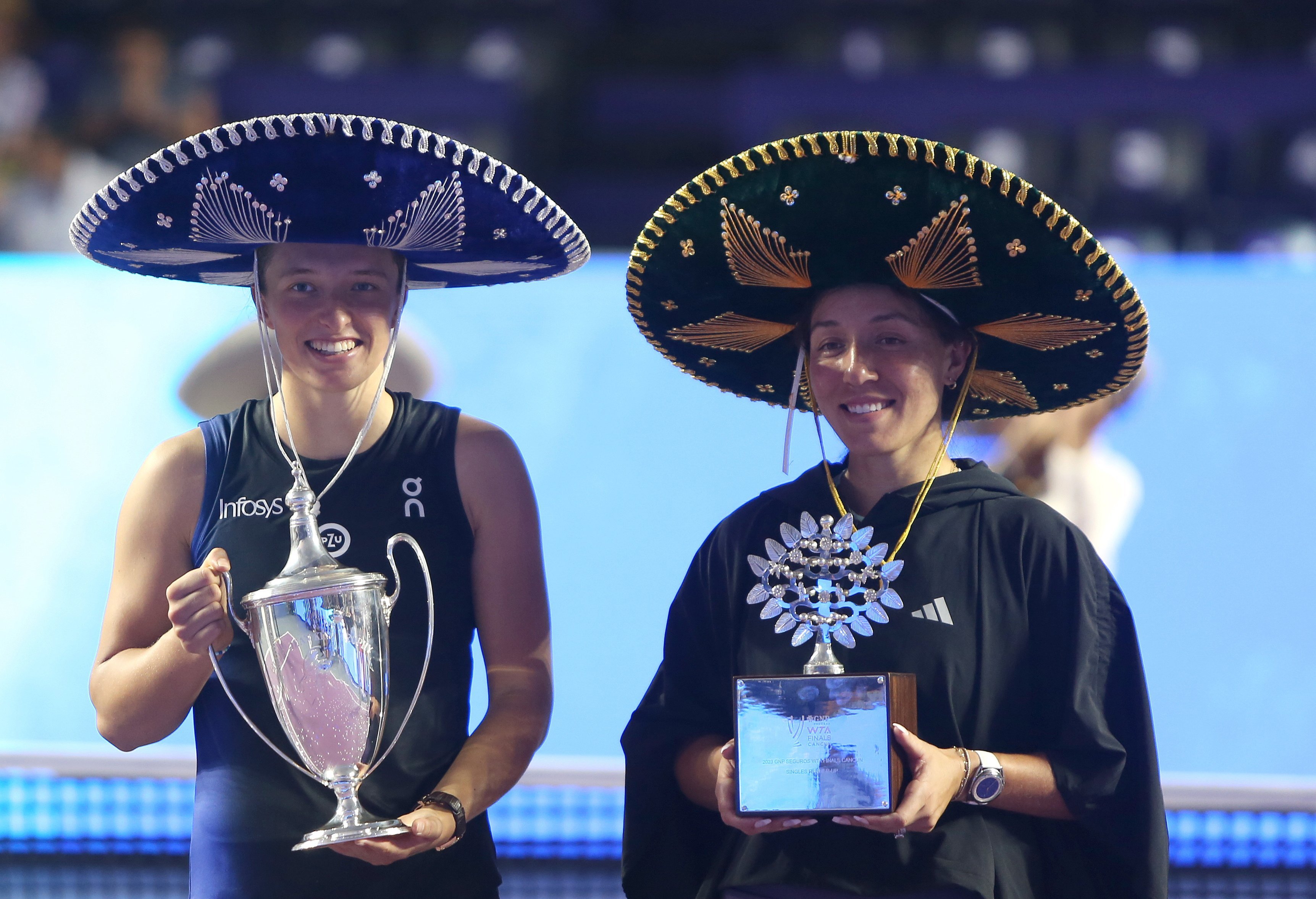Iga Swiatek of Poland (left) holds the trophy after Jessica Pegula at the WTA Finals in Cancun. Photo: EPA-EFE