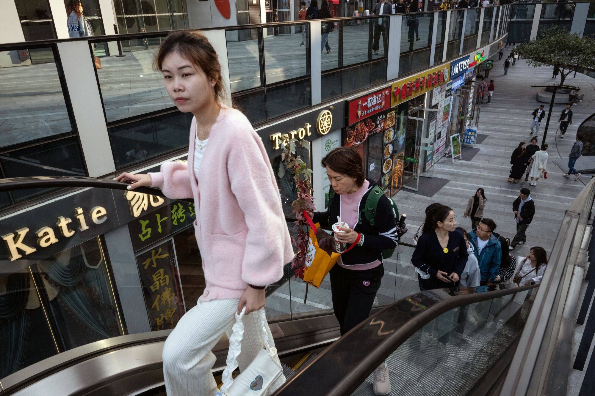 Pedestrians peruse shops in the Sanlituan area of Beijing on October 28, 2023. Photo: Bloomberg