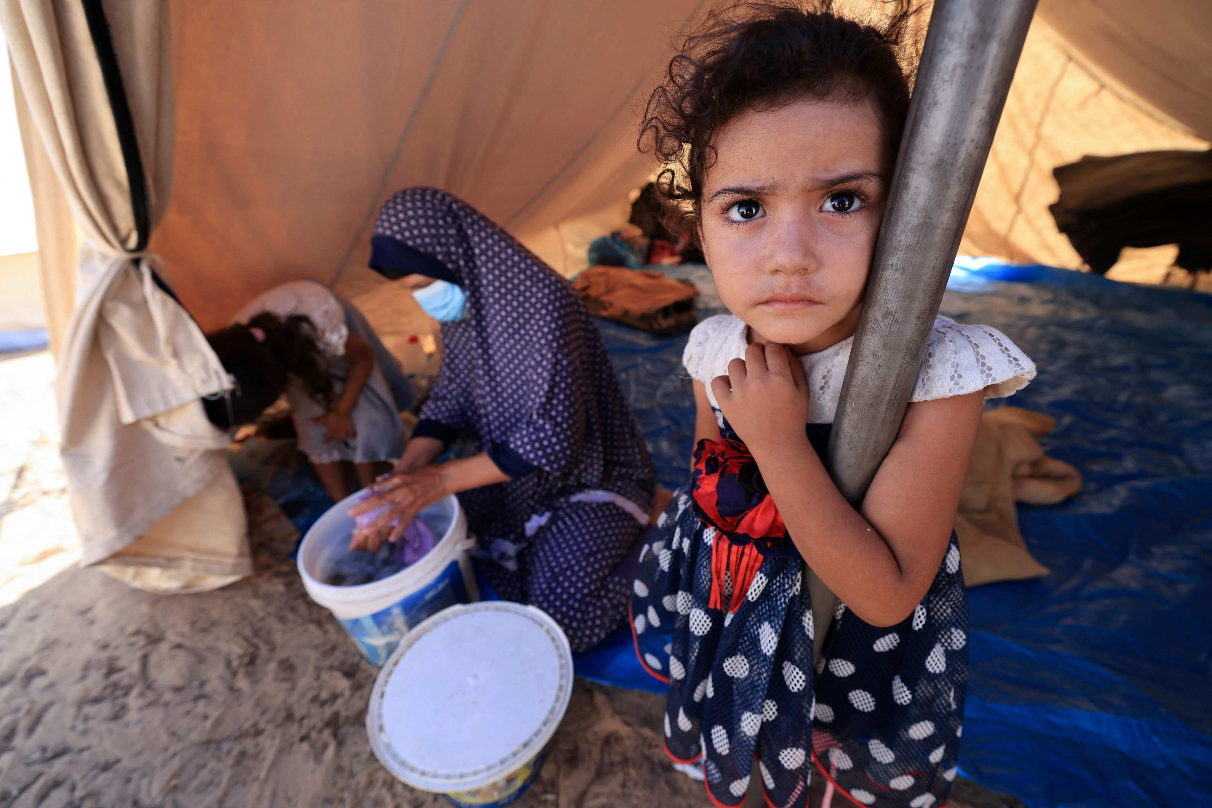 A young girl in a tent set up for Palestinians seeking refuge, in an UNRWA centre in Khan Yunis in the southern Gaza Strip on October 19. Entire city blocks have been levelled, water, food and power have been cut off, and over one million people have been displaced. Photo: AFP