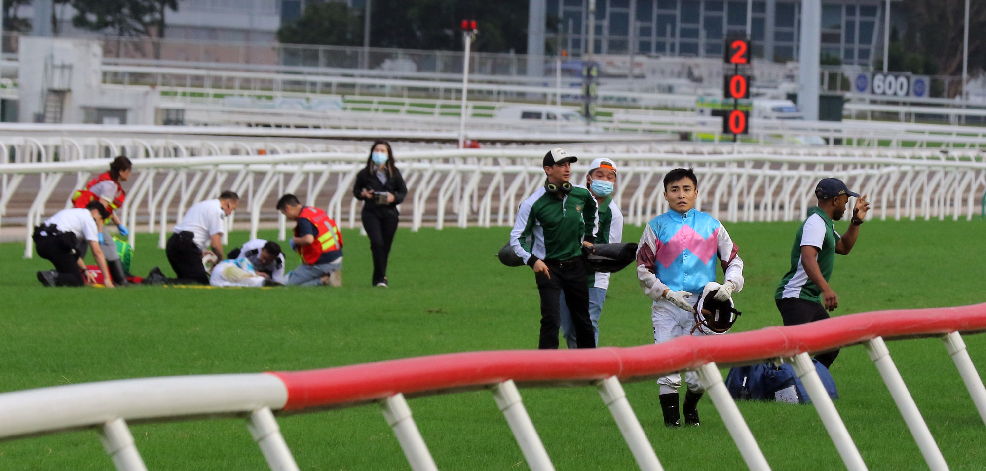 Medical staff attend to Hugh Bowman following the Panasonic Cup race fall as Keith Yeung walks off the track.