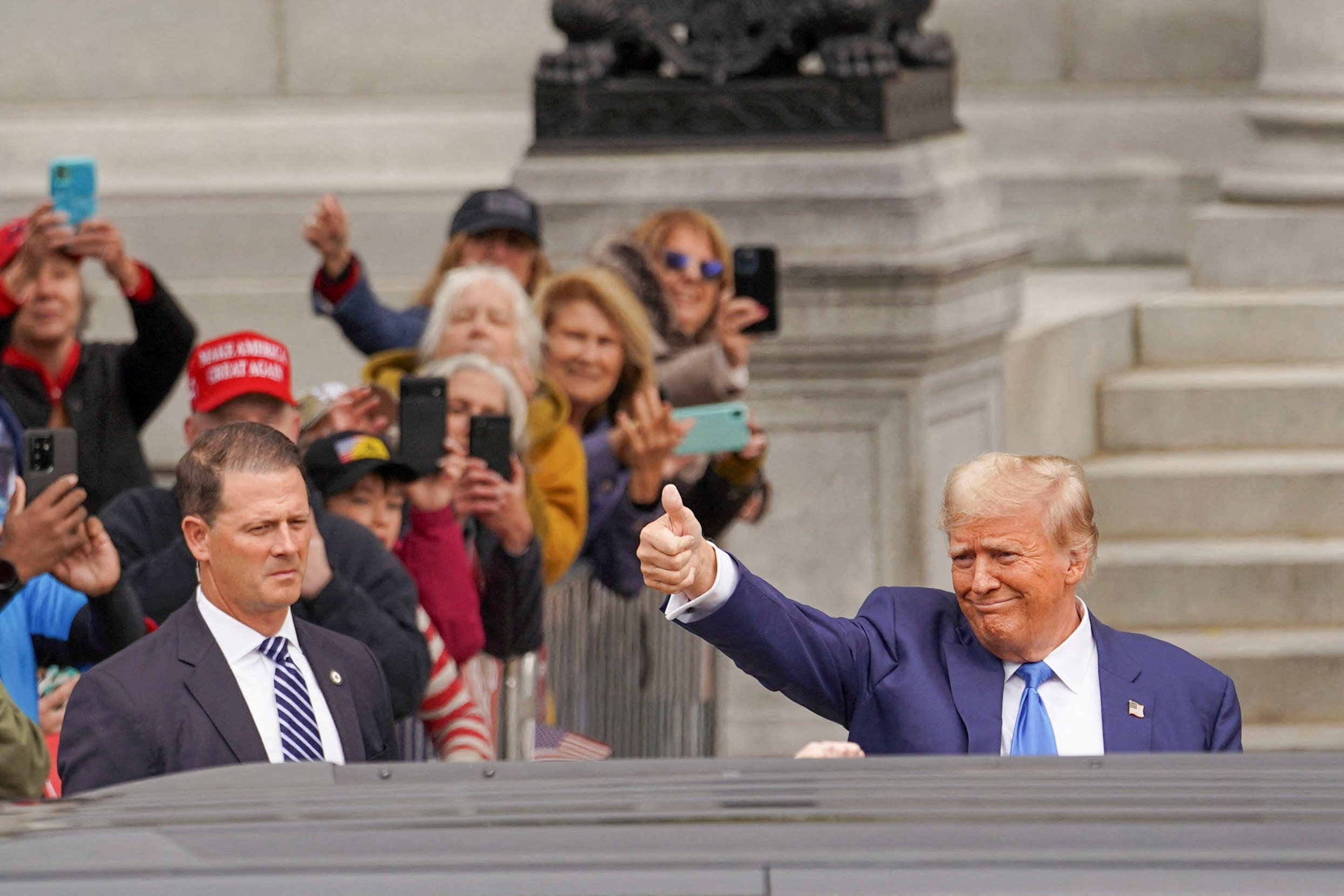 Republican presidential candidate Donald Trump gives a thumbs-up to supporters after filing the paperwork to put his name on the ballot for the primary election in Concord, New Hampshire, on October 23. Photo: Reuters