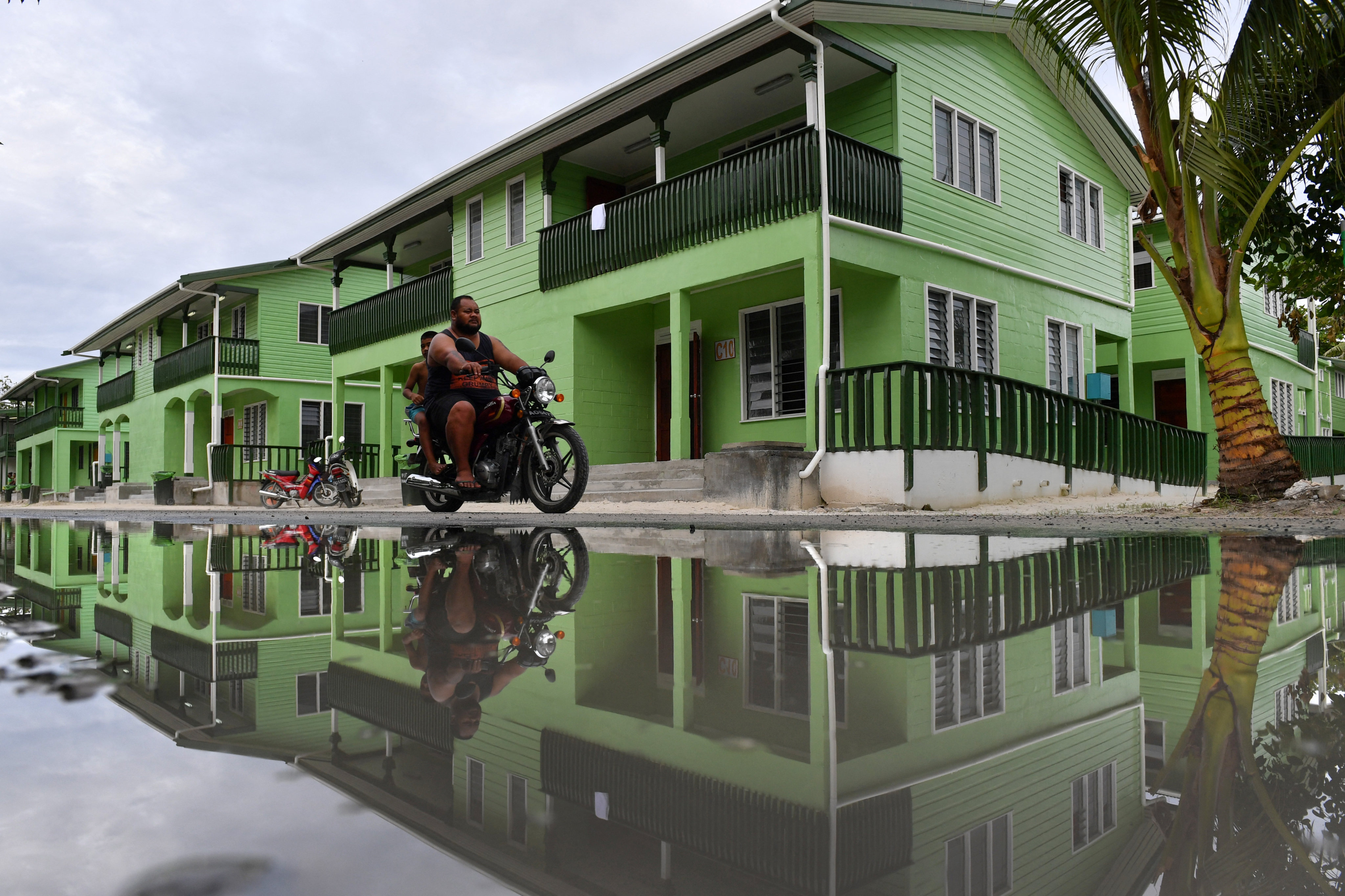 A person rides past a puddle of water in Funafuti, Tuvalu. Photo: AAP via Reuters