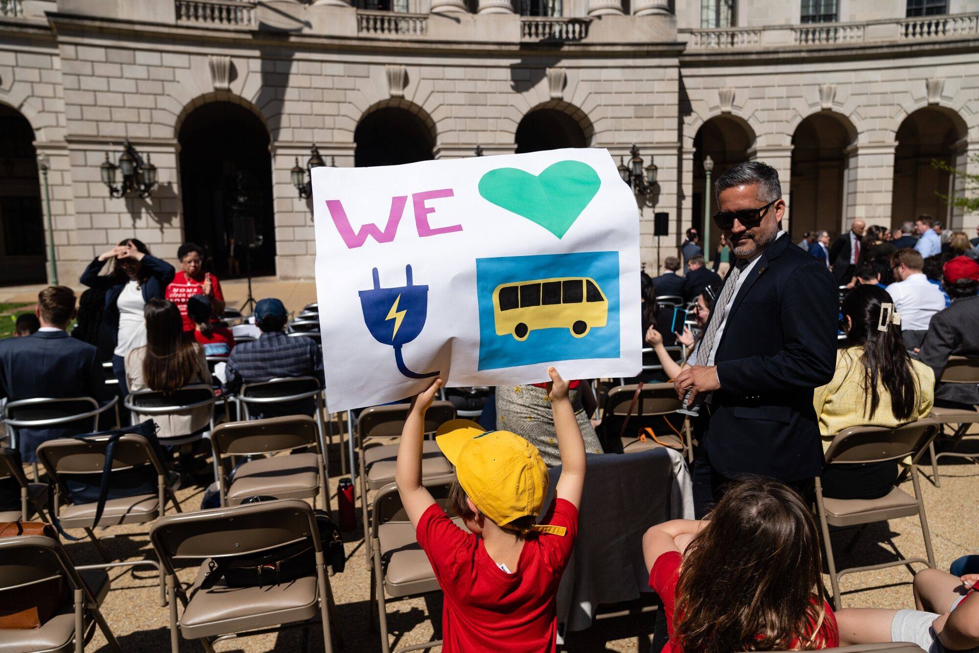 A young EV supporter holds up a poster at a Washington news conference on April 12. Currently, at least nine US states are pivoting towards EVs and planning to ban the sale of new combustion engine cars after 2035, with several other states considering joining them.  Photo: Bloomberg