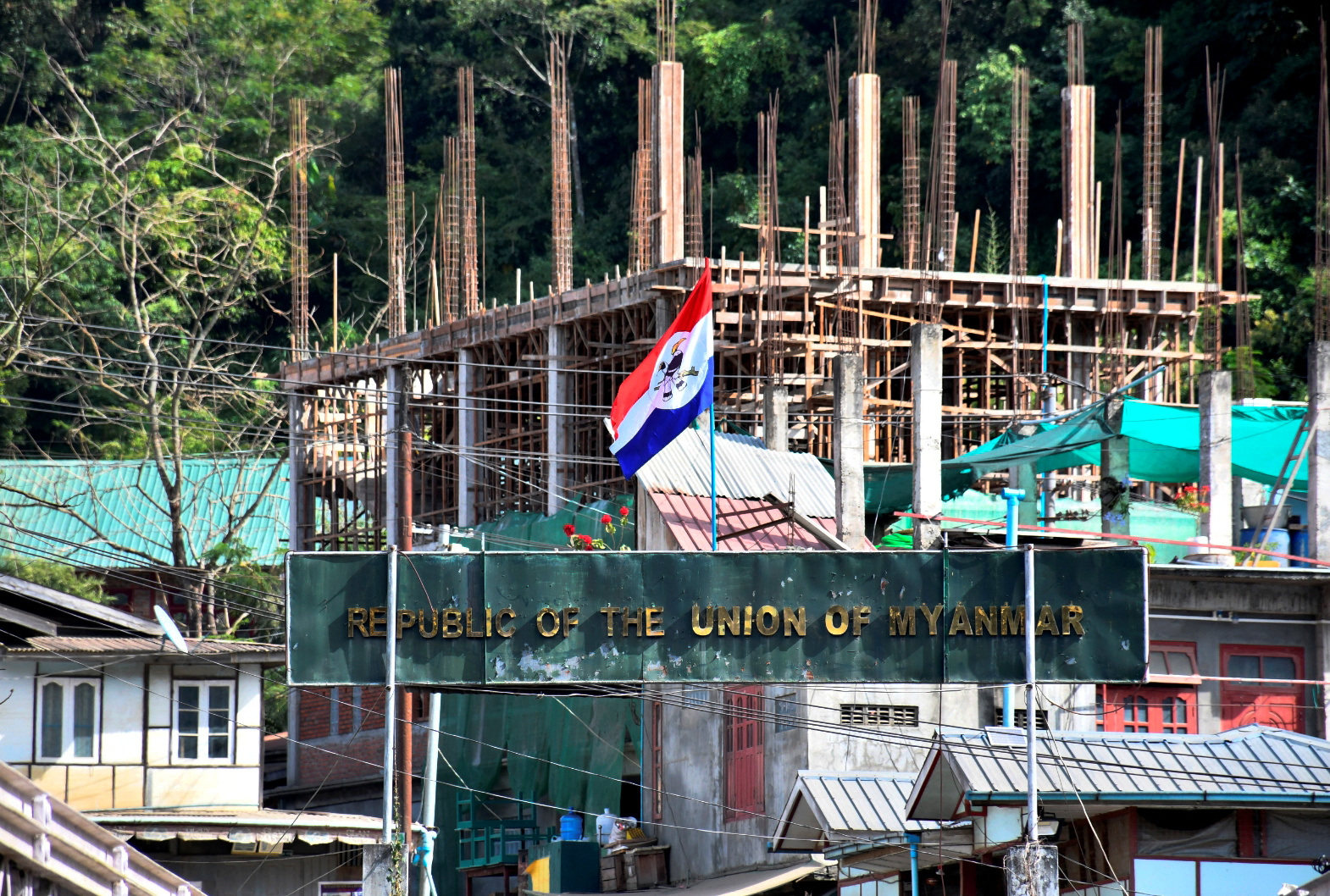A flag of one of the Myanmar rebel forces is installed next to an under-construction structure in Myanmar’s Khawmawi village on the India-Myanmar border as seen from Zokhawthar village in Champhai district of India’s northeastern state of Mizoram, India, on Tuesday. Photo: Reuters