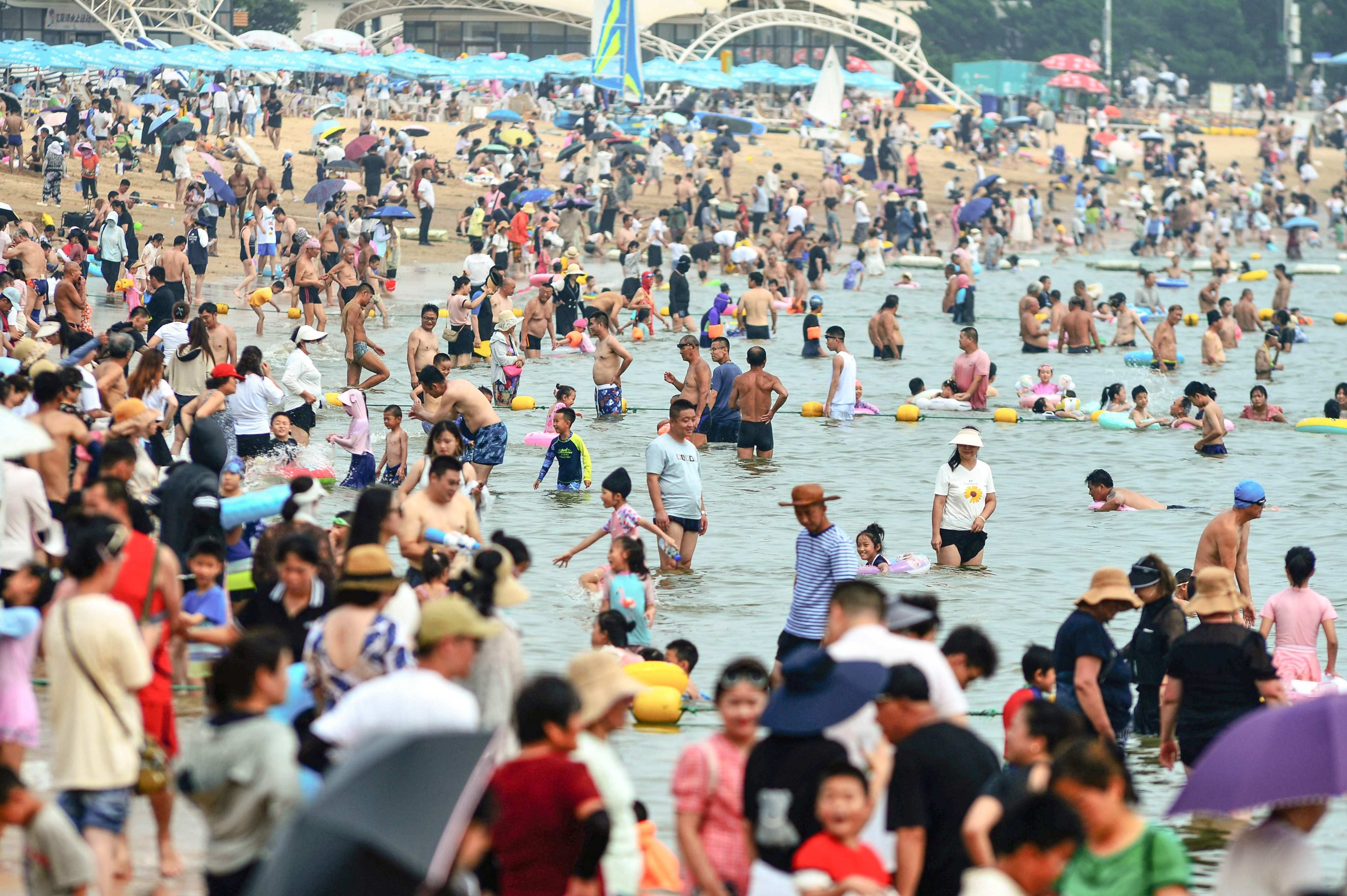 People cool off on a beach amid hot weather in Qingdao, in China’s eastern Shandong province in July. James Hansen, a former top Nasa scientist, has warned that the world’s average temperature will surpass the 1.5-degree threshold within the 2020s. Photo: AFP