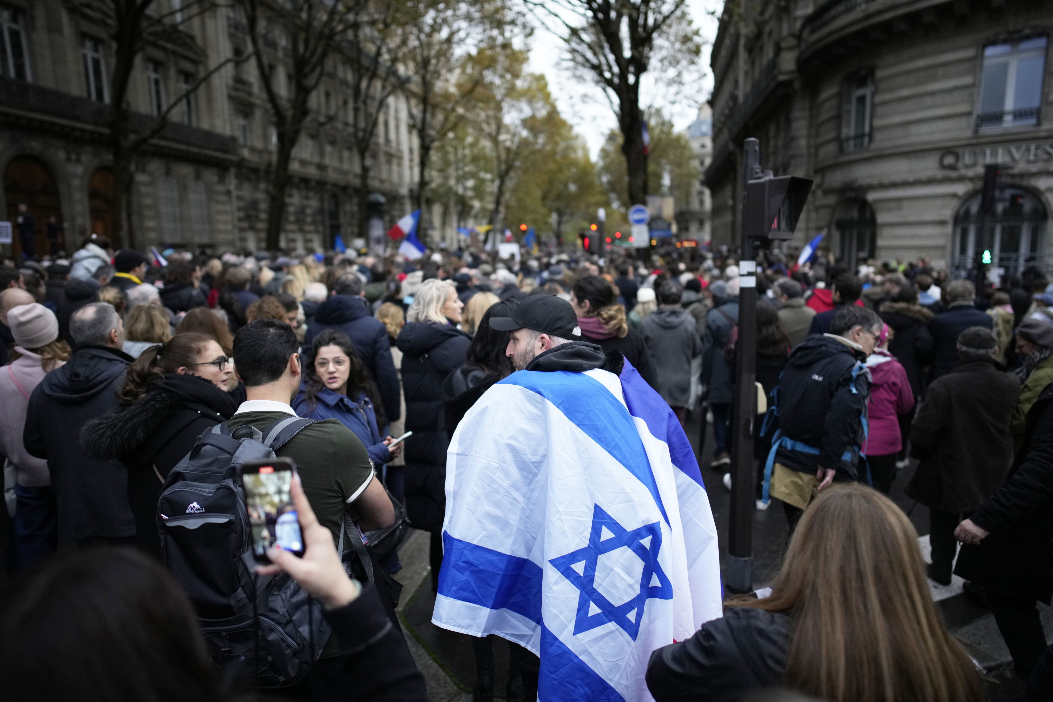 A demonstrator wearing an Israeli flag joins thousands of other people for a march against antisemitism in Paris, France, on Sunday. Photo: AP