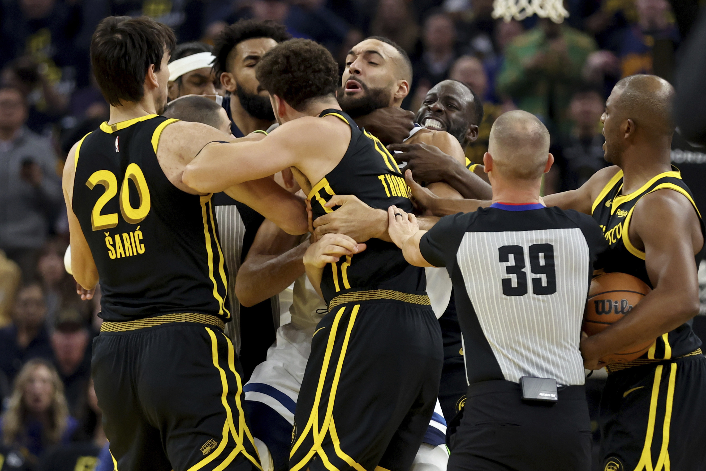 Golden State Warriors’ Draymond Green puts Rudy Gobert in a chokehold, which gets him a five-game suspension. Photo: AP