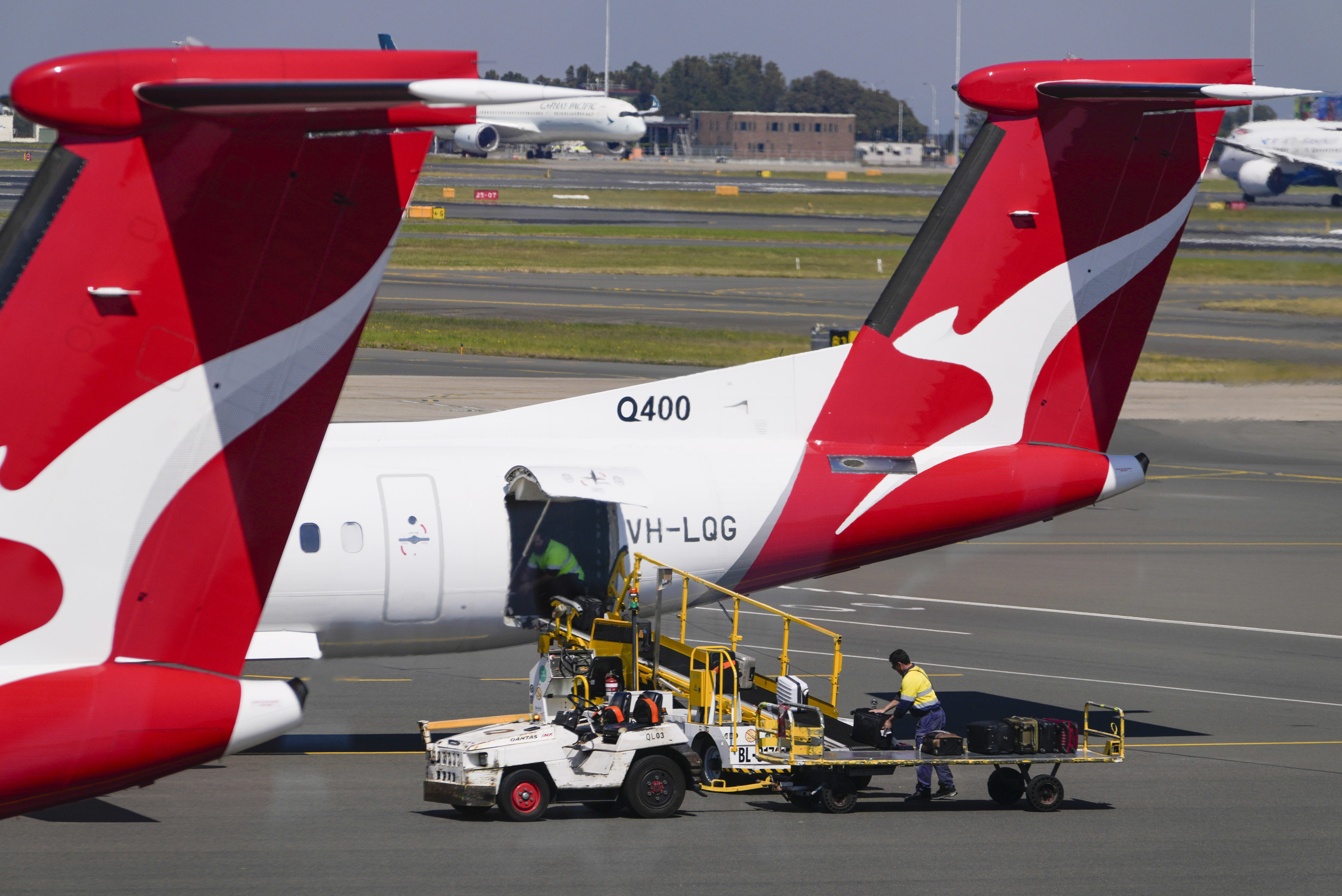 Baggage handlers work near a Qantas plane at Sydney’s domestic terminal. Photo: AP