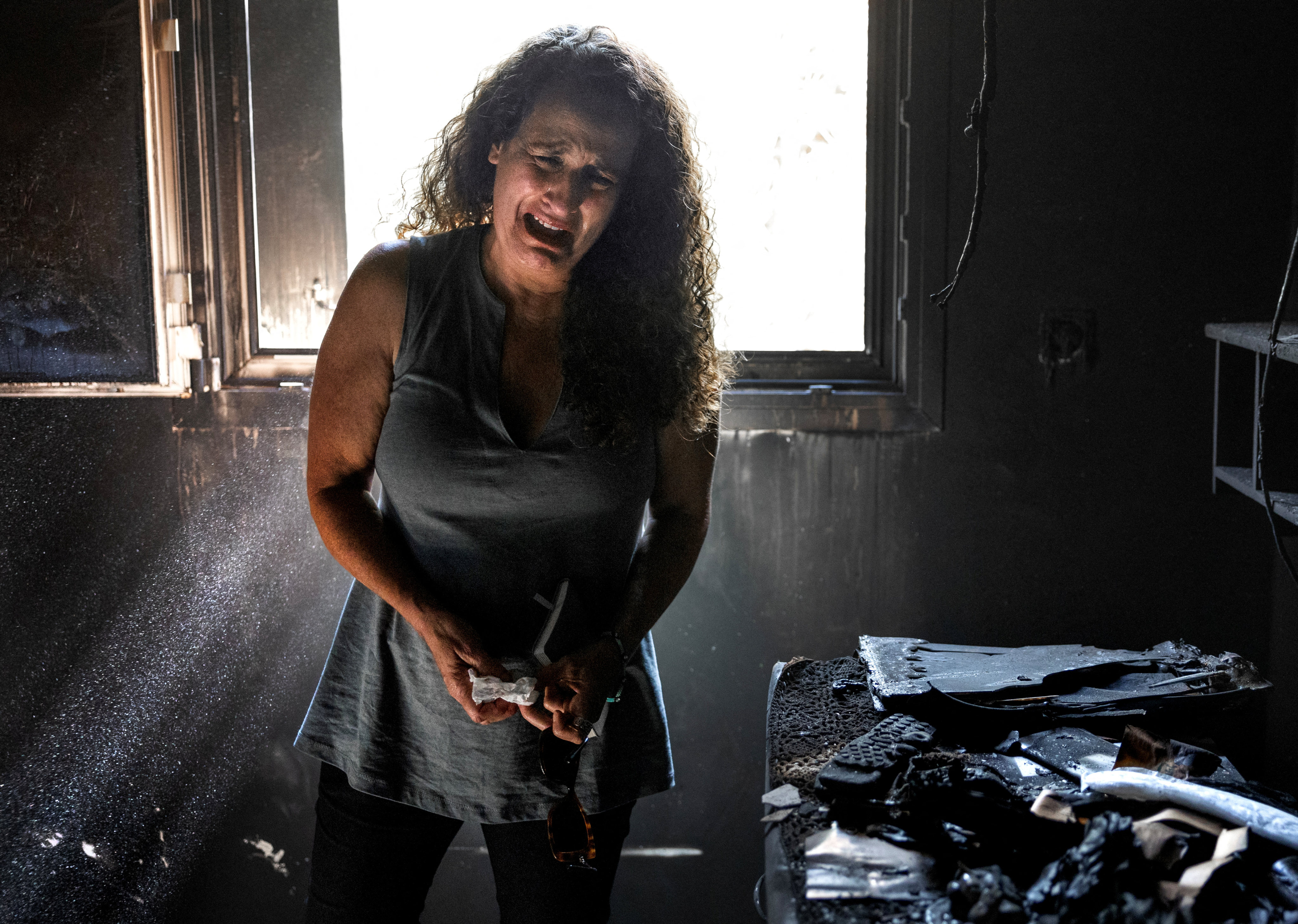 A woman, whose mother and niece were killed in Hamas’ attack on October 7, cries in the burned-out remains of her mother’s home in Kibbutz Nir Oz, in southern Israel, on October 30. Three members of the family - two children and their father - were kidnapped. Photo: Reuters