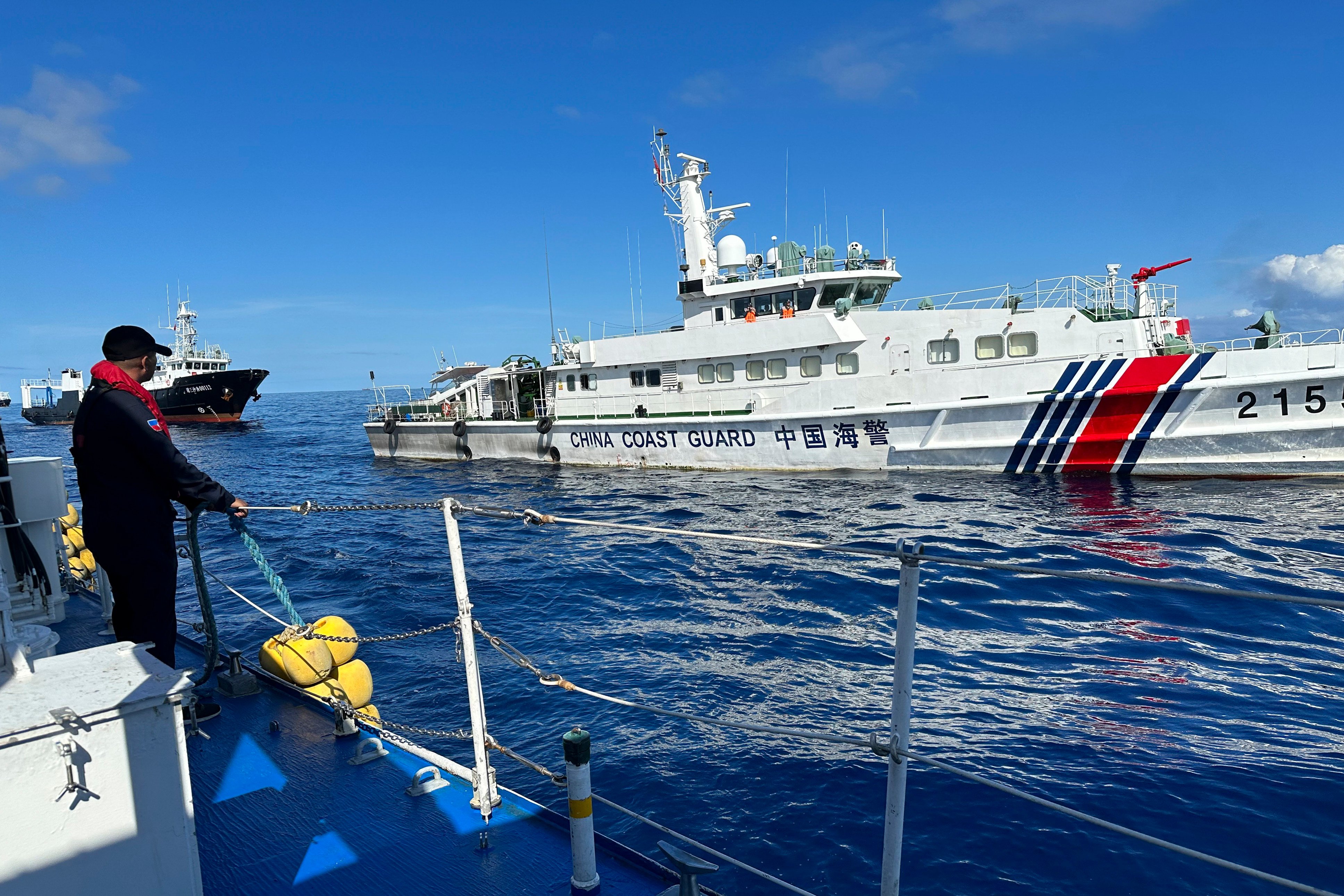 A Philippine Coast Guard member holds on a rubber fender as a Chinese coastguard vessel and suspected Chinese militia ship chases the Philippine coastguard vessel BRP Cabra at the disputed South China Sea on November 10. Photo: AP