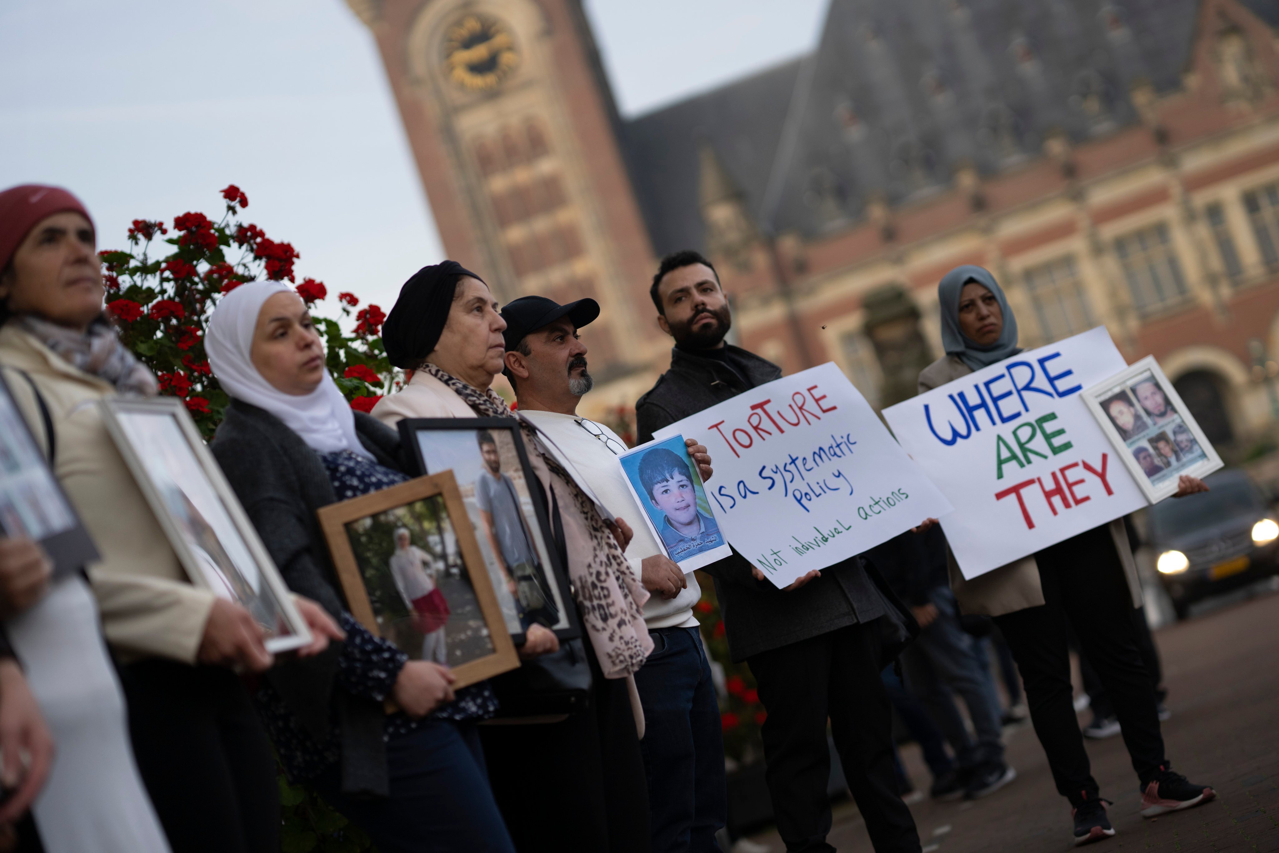 Demonstrators display pictures of people they say disappeared in Syria, outside the International Court of Justice in The Hague on Tuesday. Photo: AP