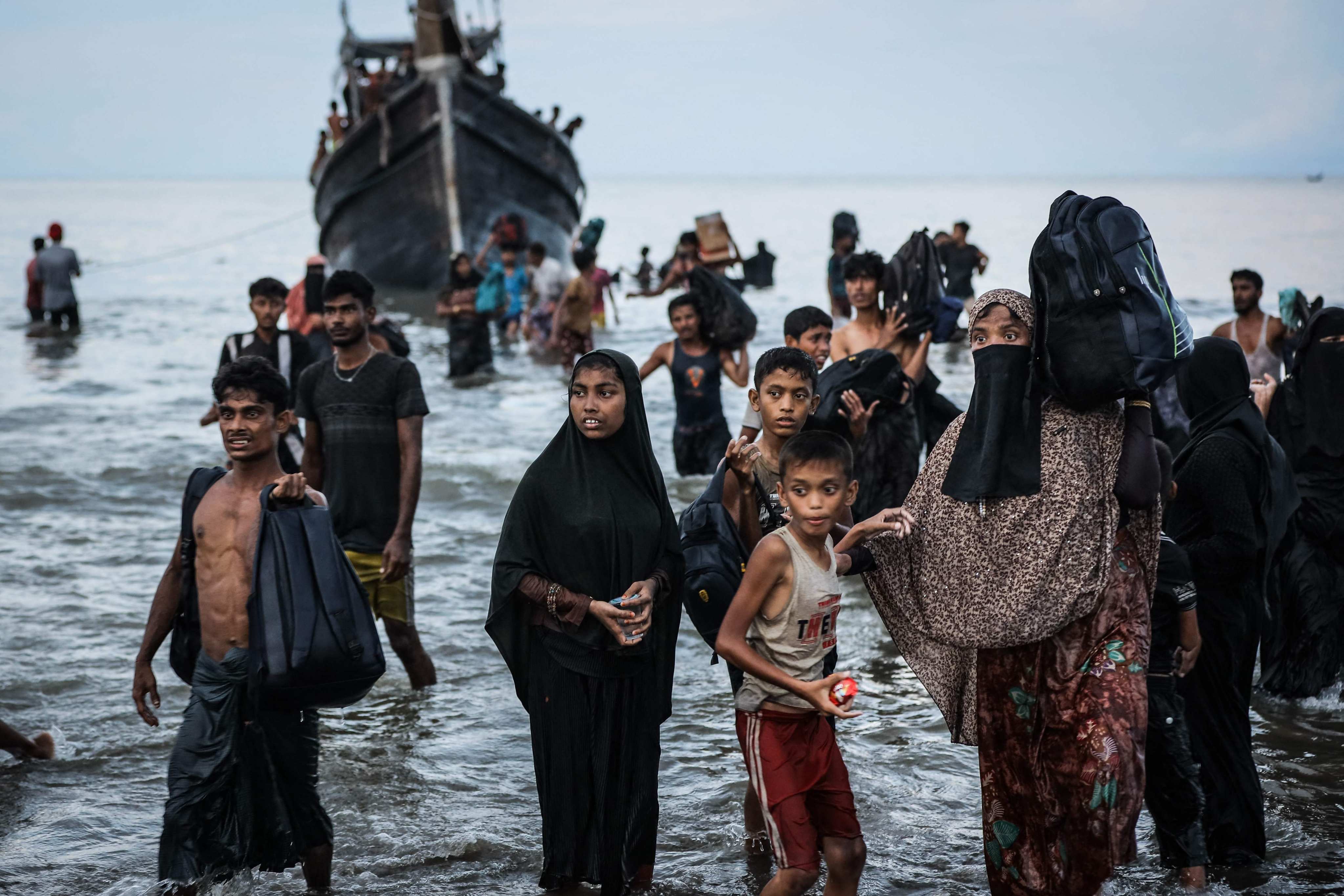 Rohingya refugees return to a boat after the local community temporarily allowed them to land for water and food in Aceh province, Indonesia, on Thursday. Photo: AFP