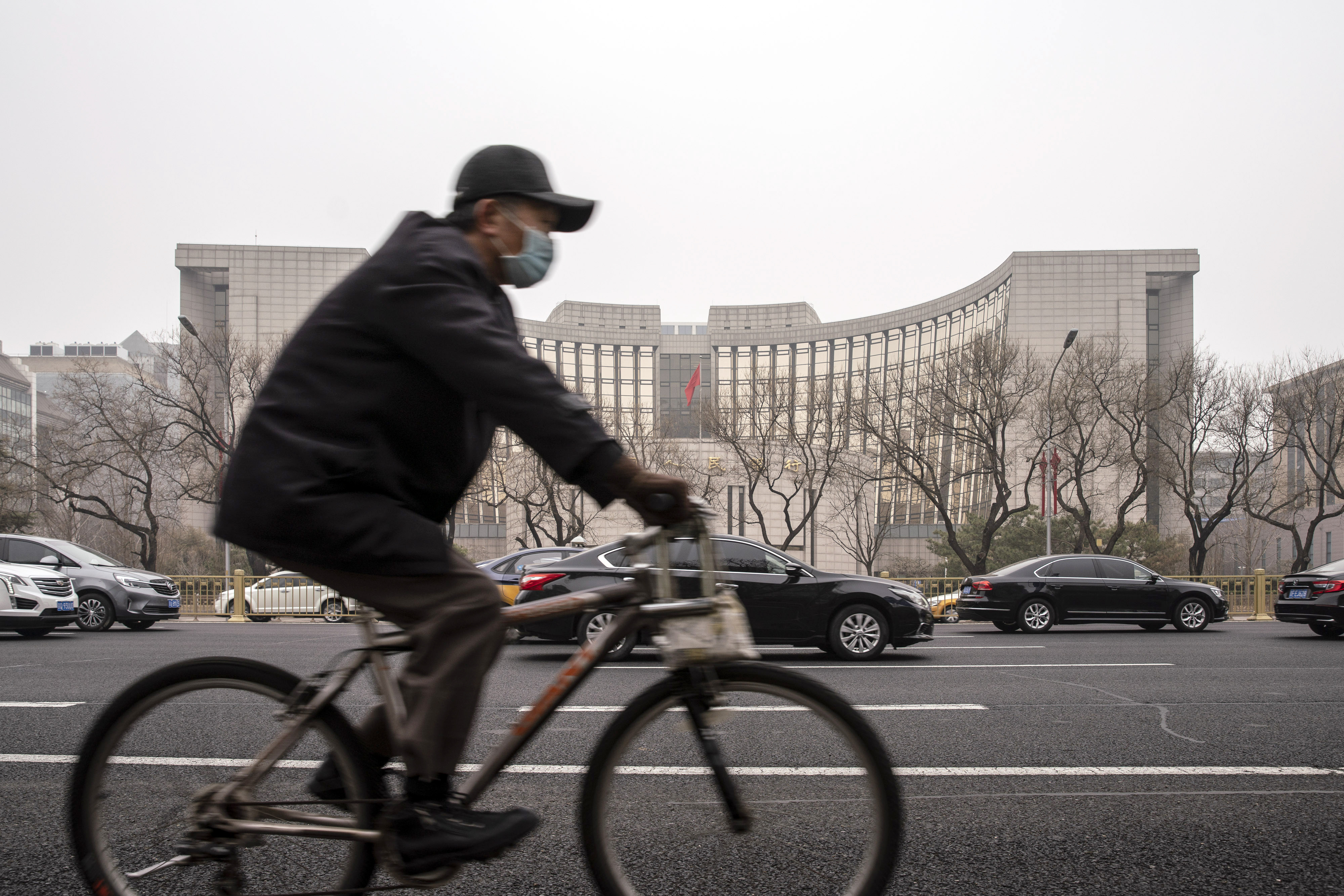 A cyclist rides past the People’s Bank of China (PBOC) building in Beijing, China. Photo: Bloomberg