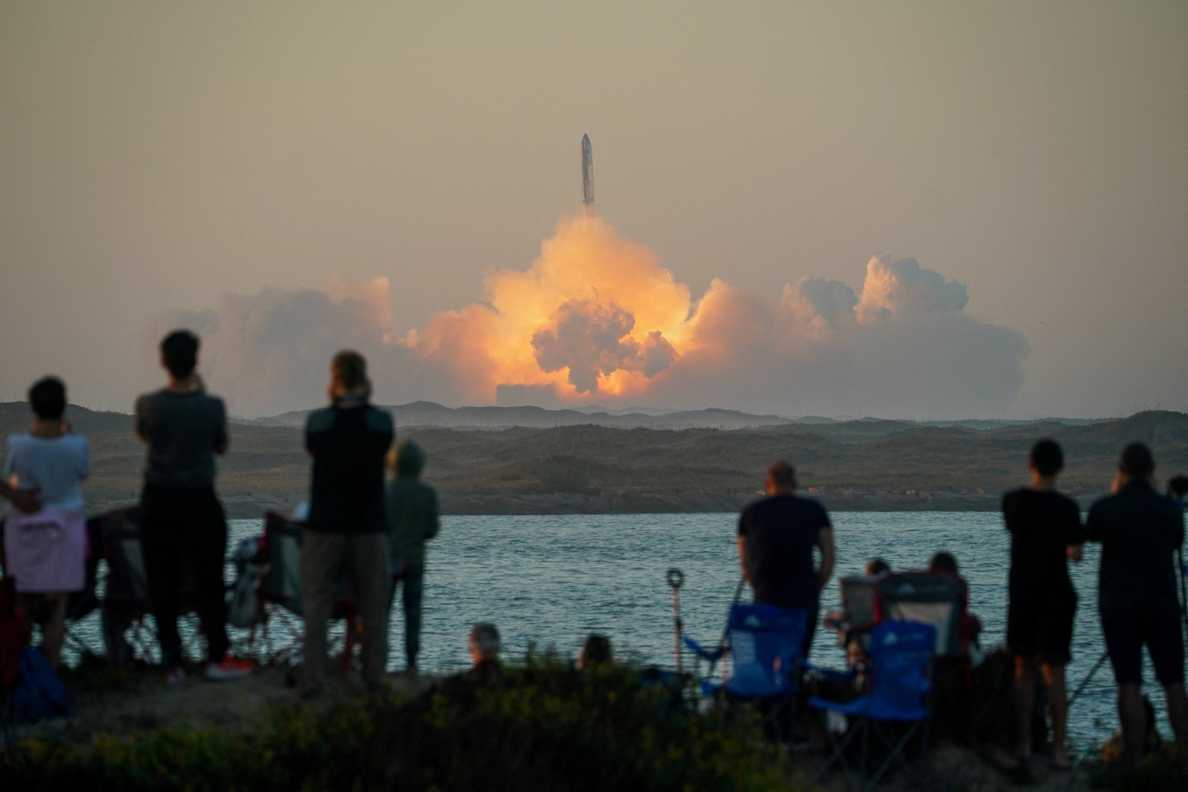 People watch as SpaceX’s next-generation Starship spacecraft atop its powerful Super Heavy rocket lifts off from the company’s Boca Chica launchpad on an uncrewed test flight, as seen from South Padre Island, near Brownsville, Texas. Photo: Reuters