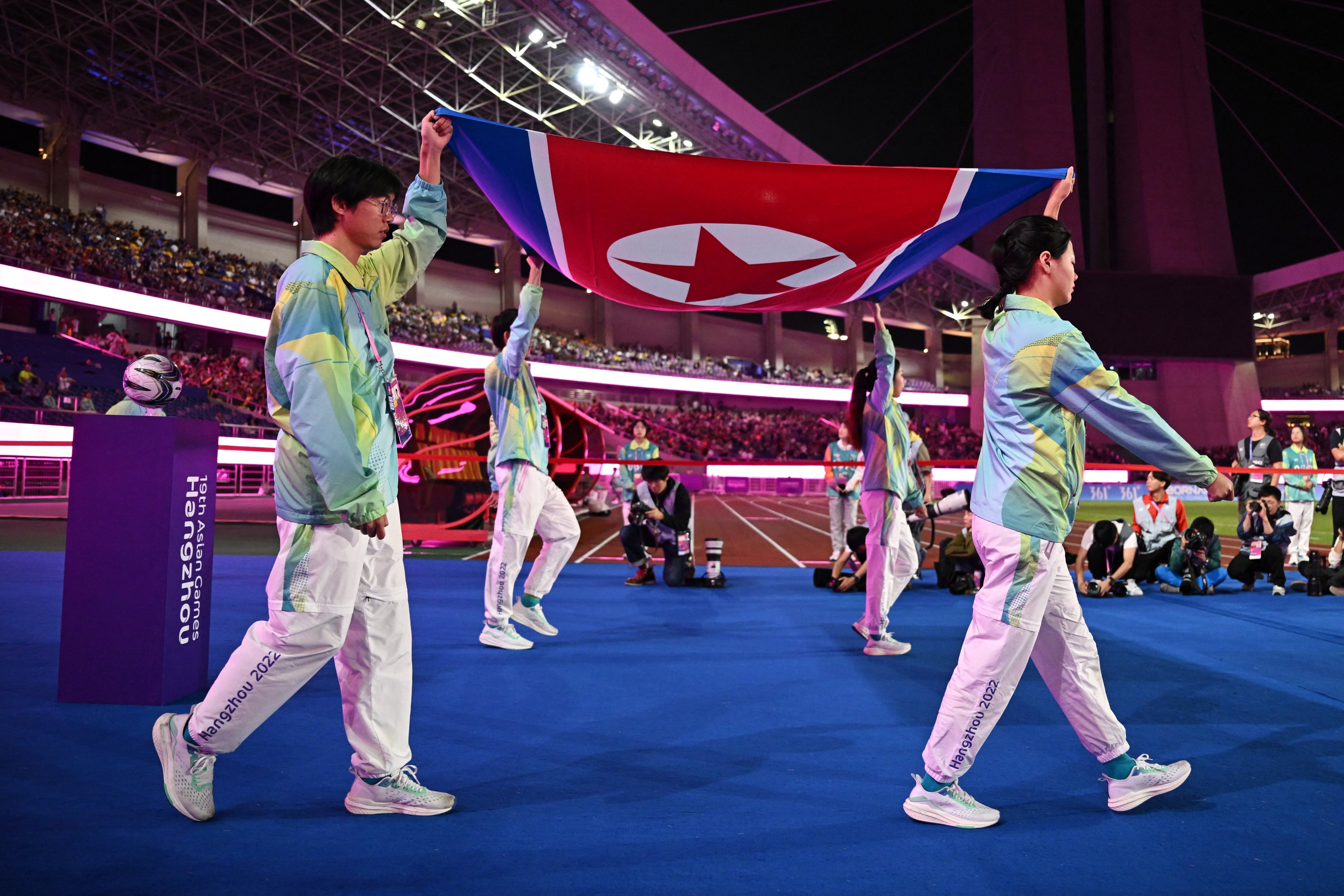 Volunteers carrying the North Korea flag walk out at Huanglong Sports Centre Stadium ahead of the women’s football gold medal match between Japan and North Korea at the Asian Games in Hangzhou. Photo: Reuters