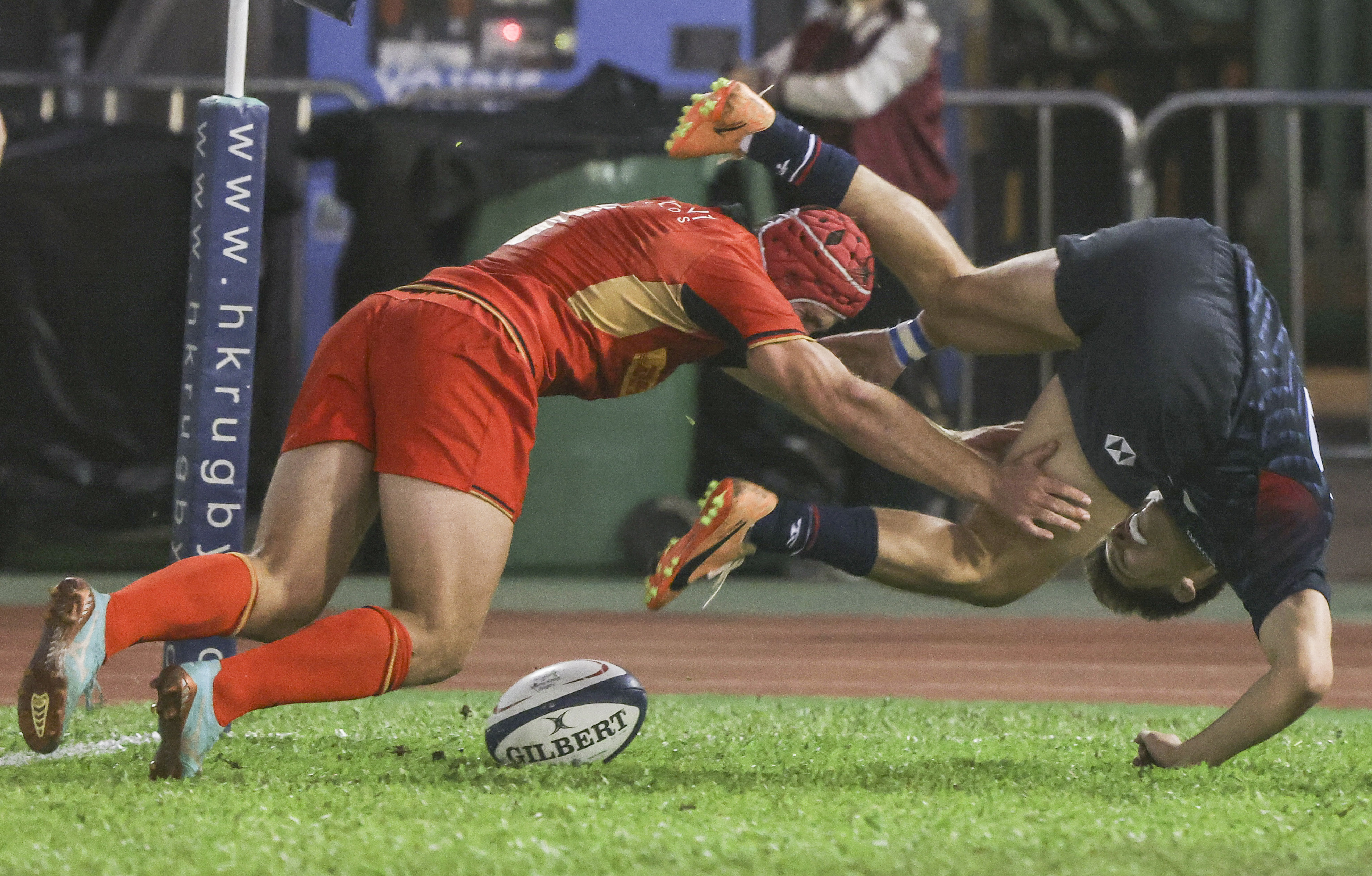 Hong Kong’s Murray Brechin dives over Germany’s Shawn Ingle to  score his first and his side’s fifth try at Aberdeen Sports Ground. Photo: Jonathan Wong