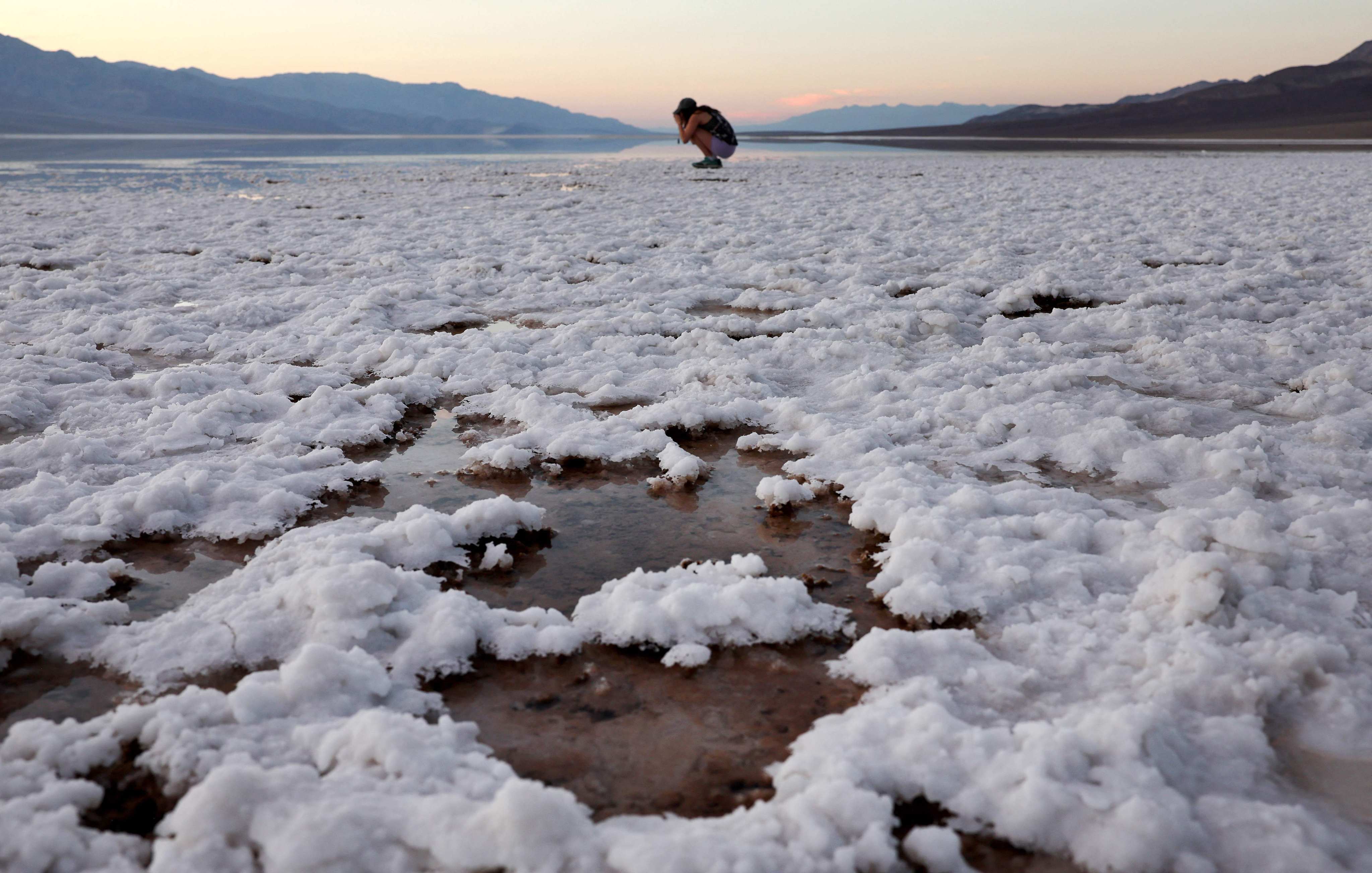 A visitor takes photos at the sprawling temporary lake at Badwater Basin salt flats in in Death Valley National Park, California, on October 21. Tropical Storm Hilary delivered a year’s worth of rain to Death Valley in a single day in August and flood damage forced the iconic desert park’s closure for eight weeks. Photo: Getty Images/AFP 