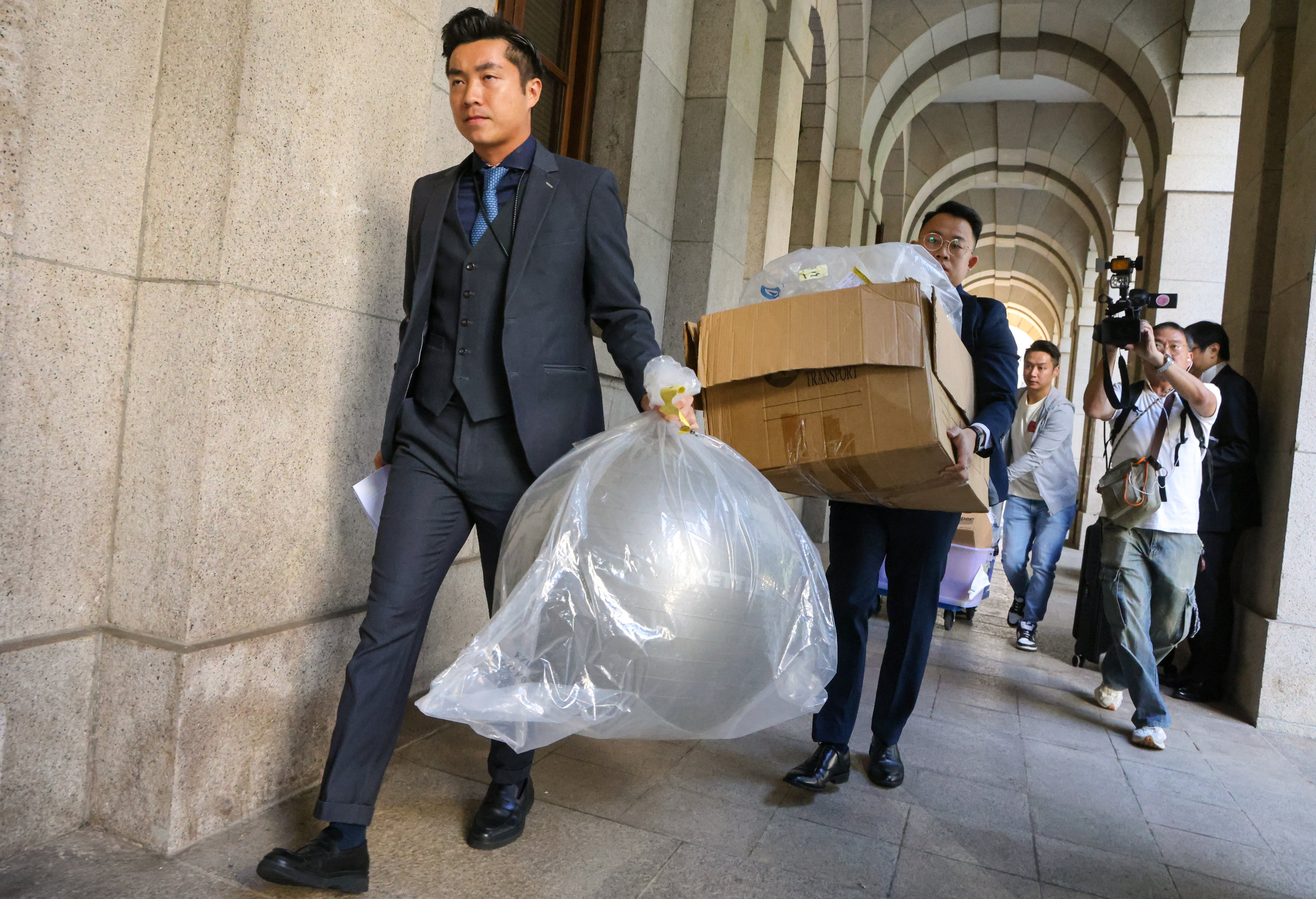 Police carrying the evidence related to the case out of the court after the ruling was declared. Photo: Dickson Lee