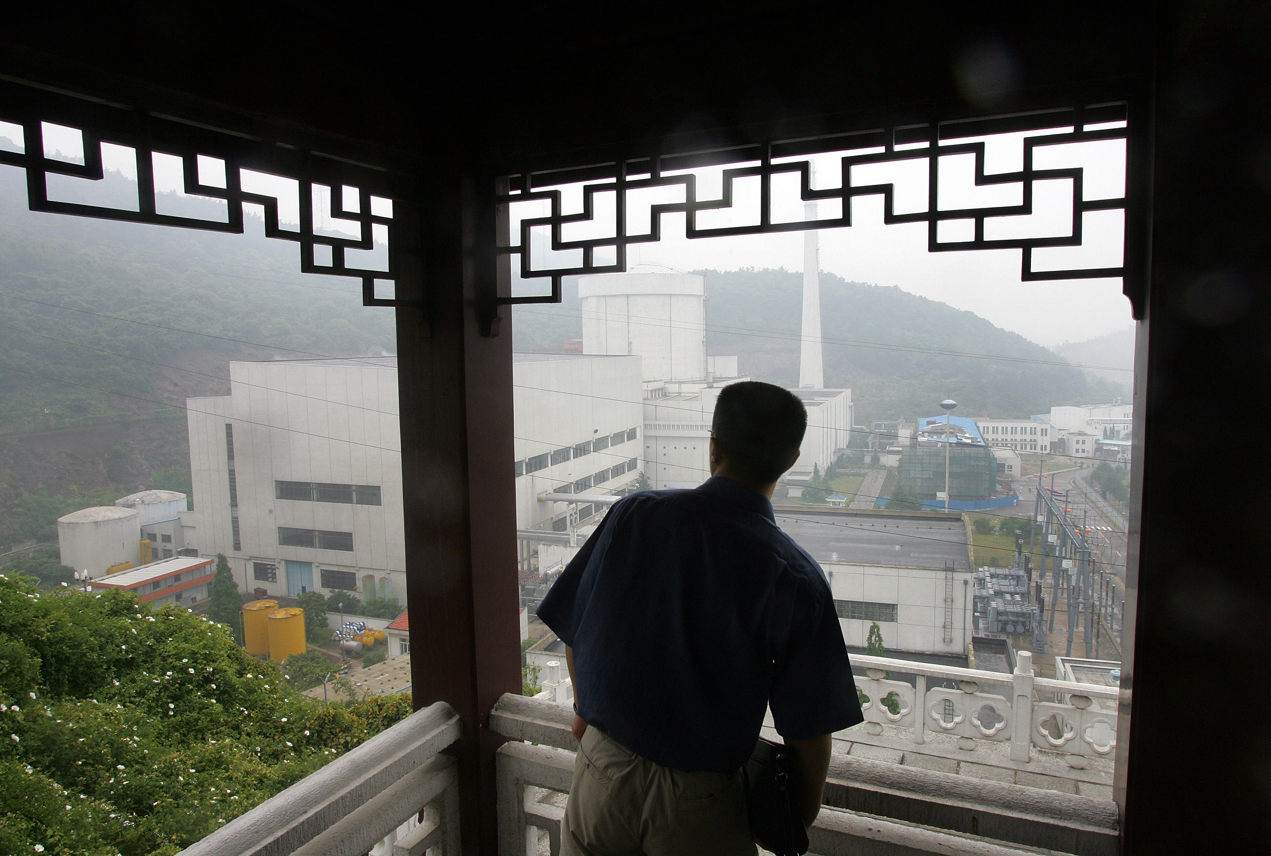 A man looks out towards the Qinshan Nuclear Power Plant while taking shelter from the rain at a hilltop overview on the outskirts of Hangzhou, Zhejiang province. Nuclear energy is an increasingly important part of Asia’s energy mix as nations pursue decarbonisation goals. Photo: AFP