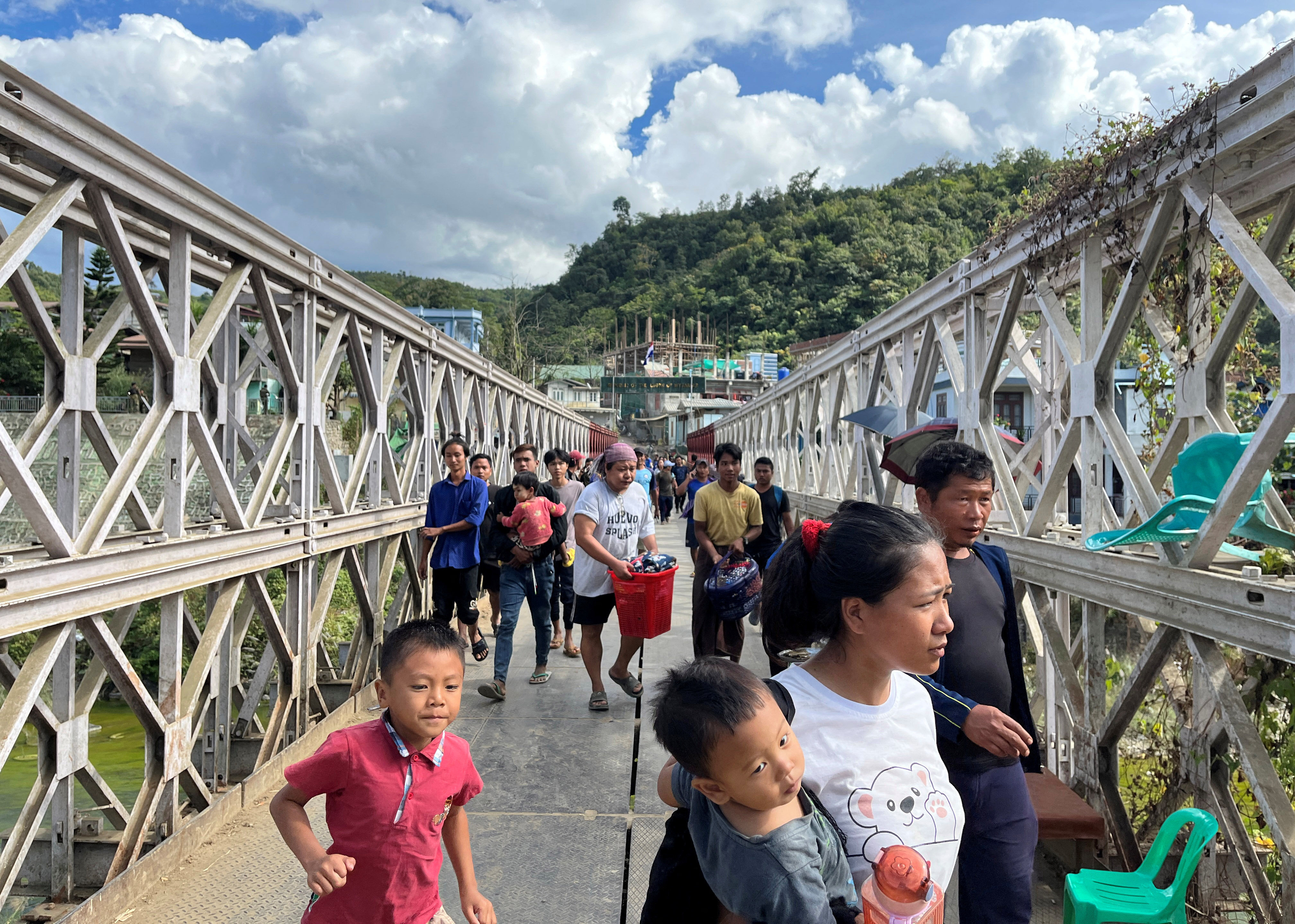 People who fled Myanmar carry their belongings across a bridge that connects Myanmar and India at the border village of Zokhawthar, Champhai district, in India’s northeastern state of Mizoram on November 15. Photo: Reuters