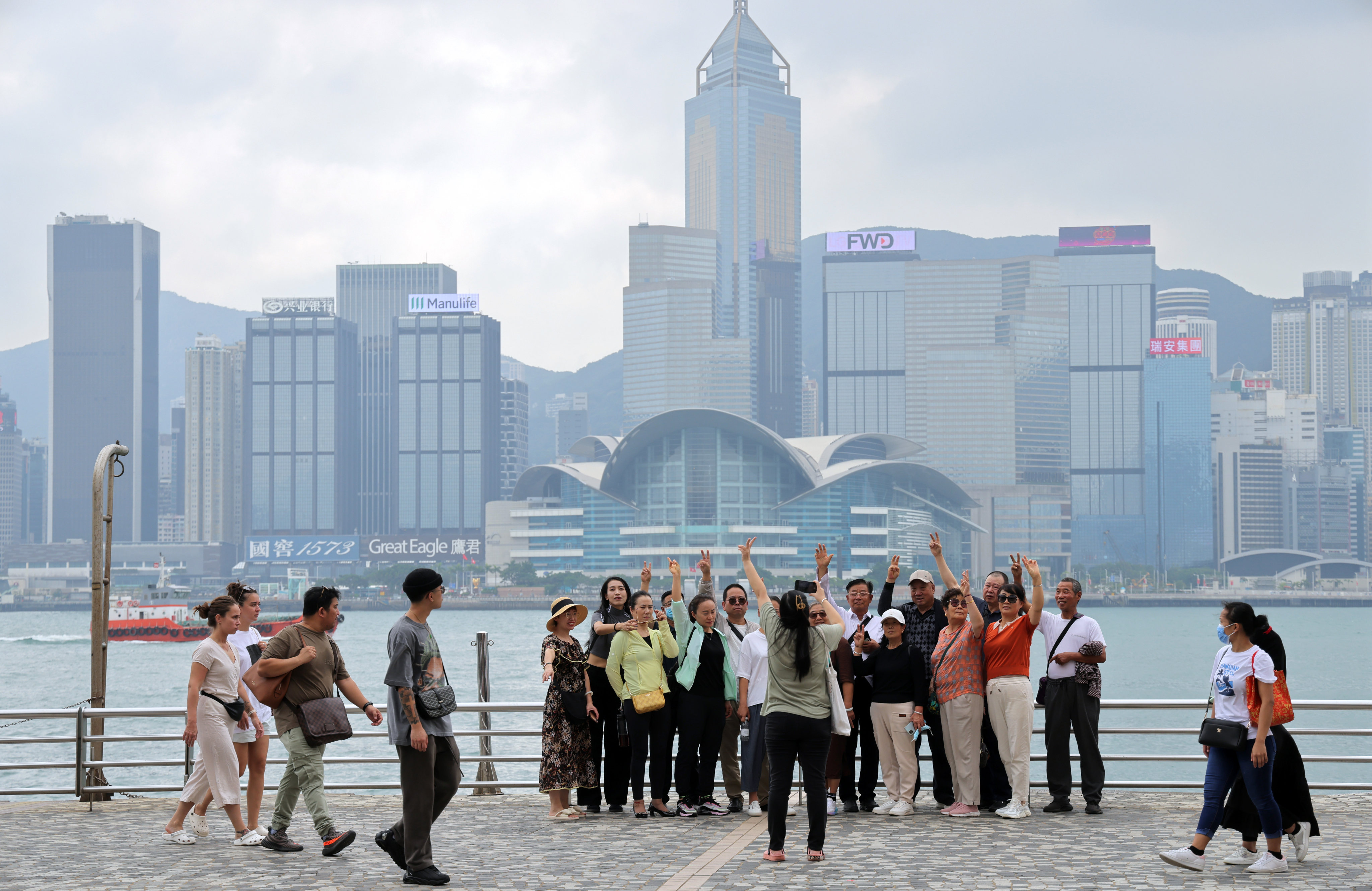 Tourists pose for a photo at the Tsim Sha Tsui waterfront. The number of tour groups from mainland China peaked in October at 6,087, a 35.8 per cent jump from the month before. Photo: Jelly Tse