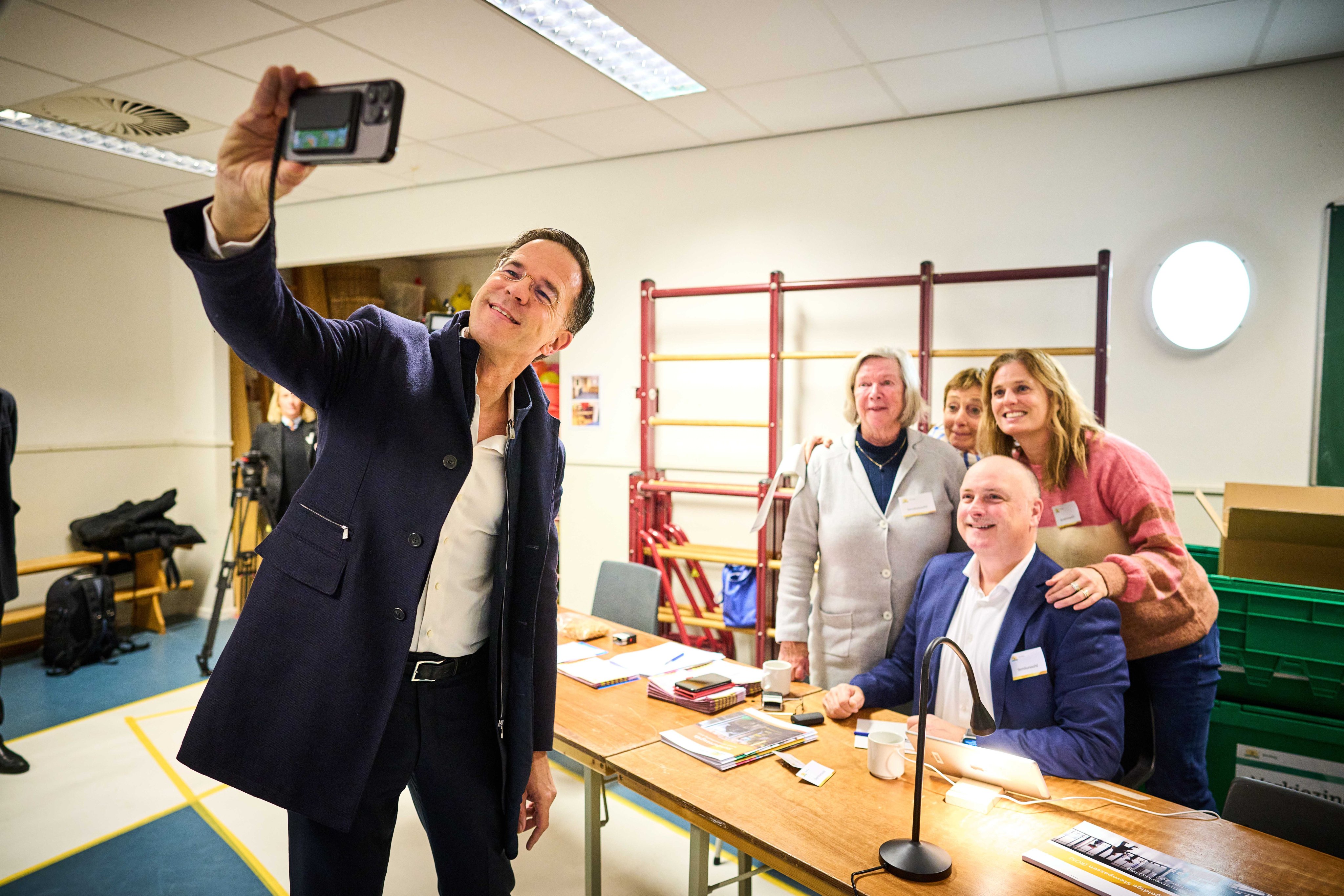 Outgoing Prime Minister Mark Rutte takes a selfie with election workers at a polling station in The Hague, the Netherlands, on Wednesday. Photo: EPA-EFE