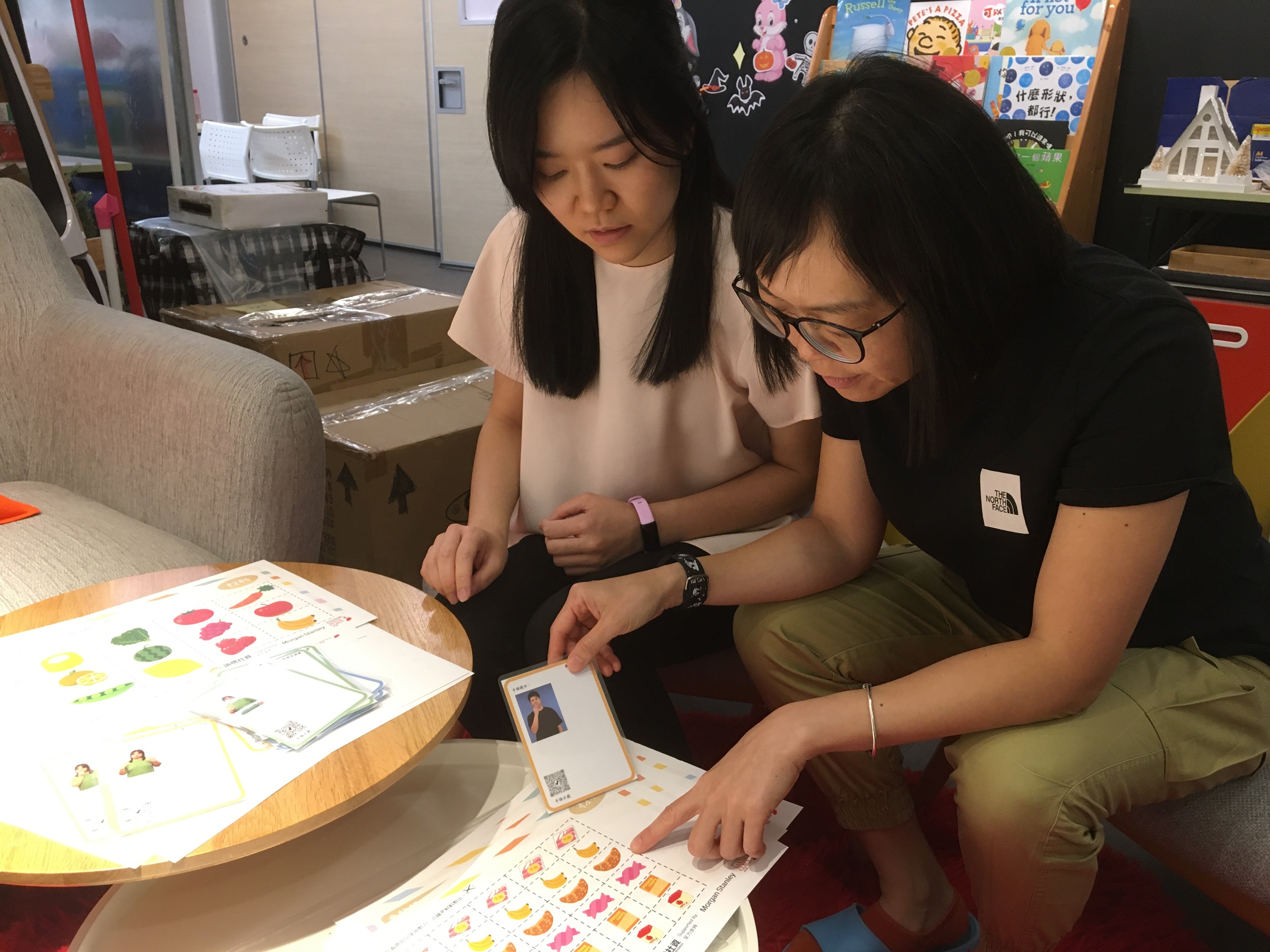 Chan Fung-mei (right), SLCO’s senior project coordinator, and Cheryl Tong Sum, a speech therapist, look over teaching material. Photo: Cindy Sui