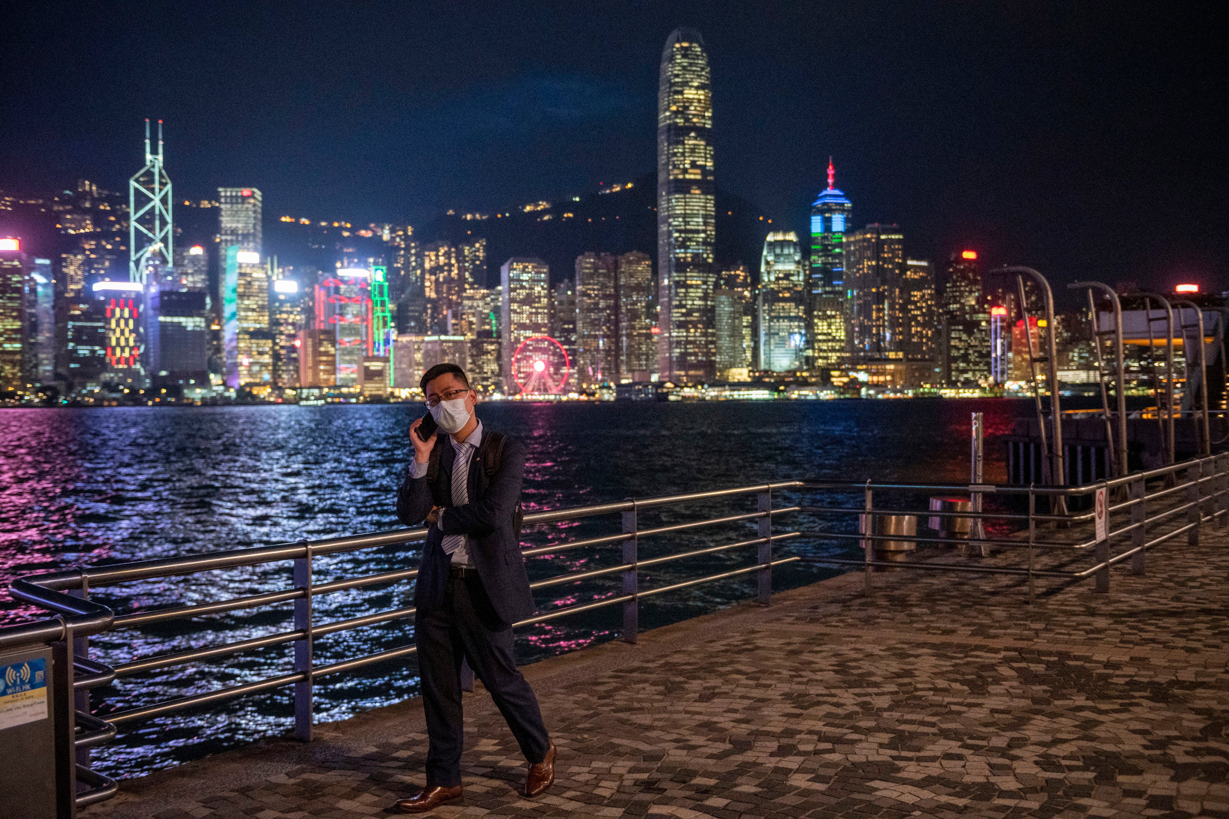 A man talks on his phone in front of the skyline in Hong Kong. The longer term implications of mainland China’s slower growth for the city are profound. Photo: AP